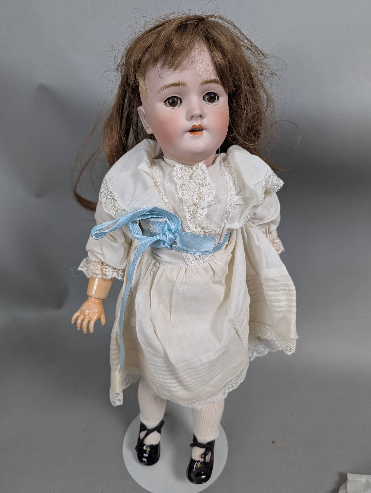 Handmade German 109-11 Composition and Bisque Doll with Lace Dress: German Handwerck 109-11 doll featuring a bisque head and composition body, measuring 20 x 8 x 3 inches. The doll has a delicate, hand-painted face with brown glass eyes, open mouth, and molded teeth.