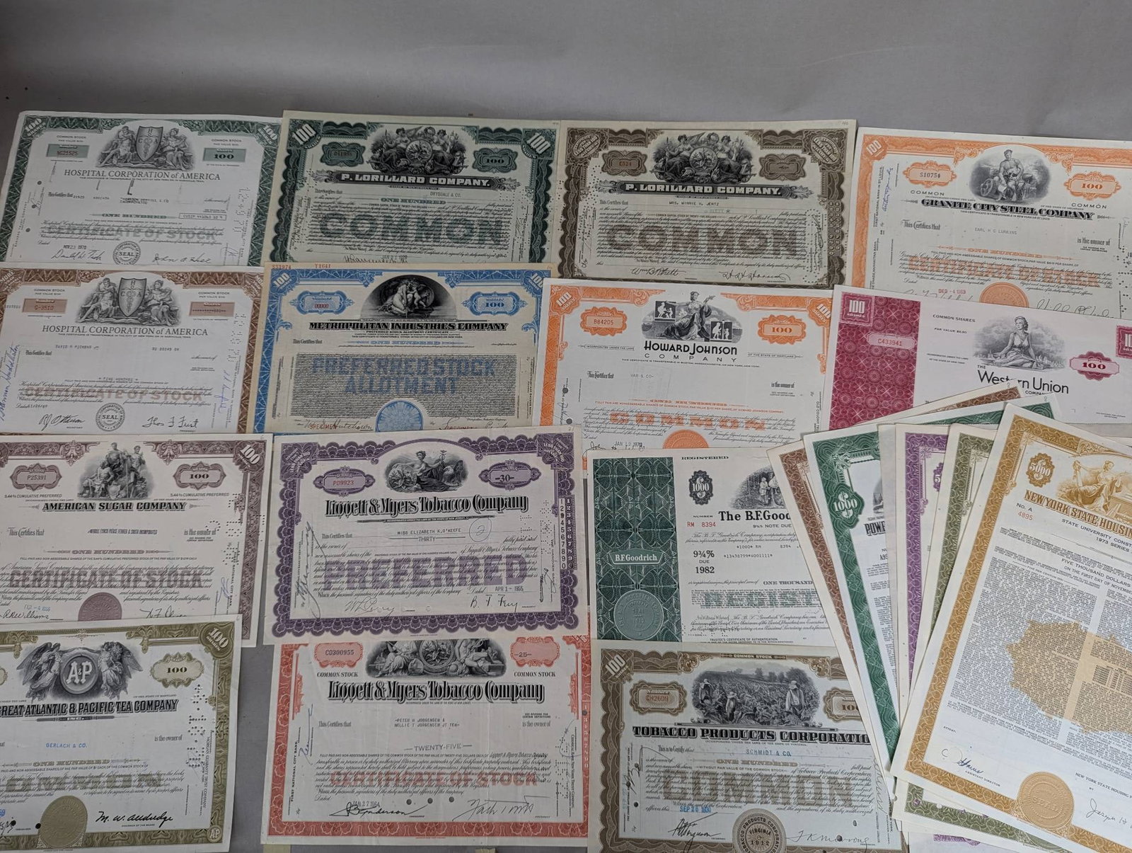 Vintage Stock Certificates from Various Historic Companies: Vintage stock certificates featuring various companies and organizations. The lot includes certificates from industries like tobacco, sugar manufacturing, insurance, and more, such as P Lorillard Comp