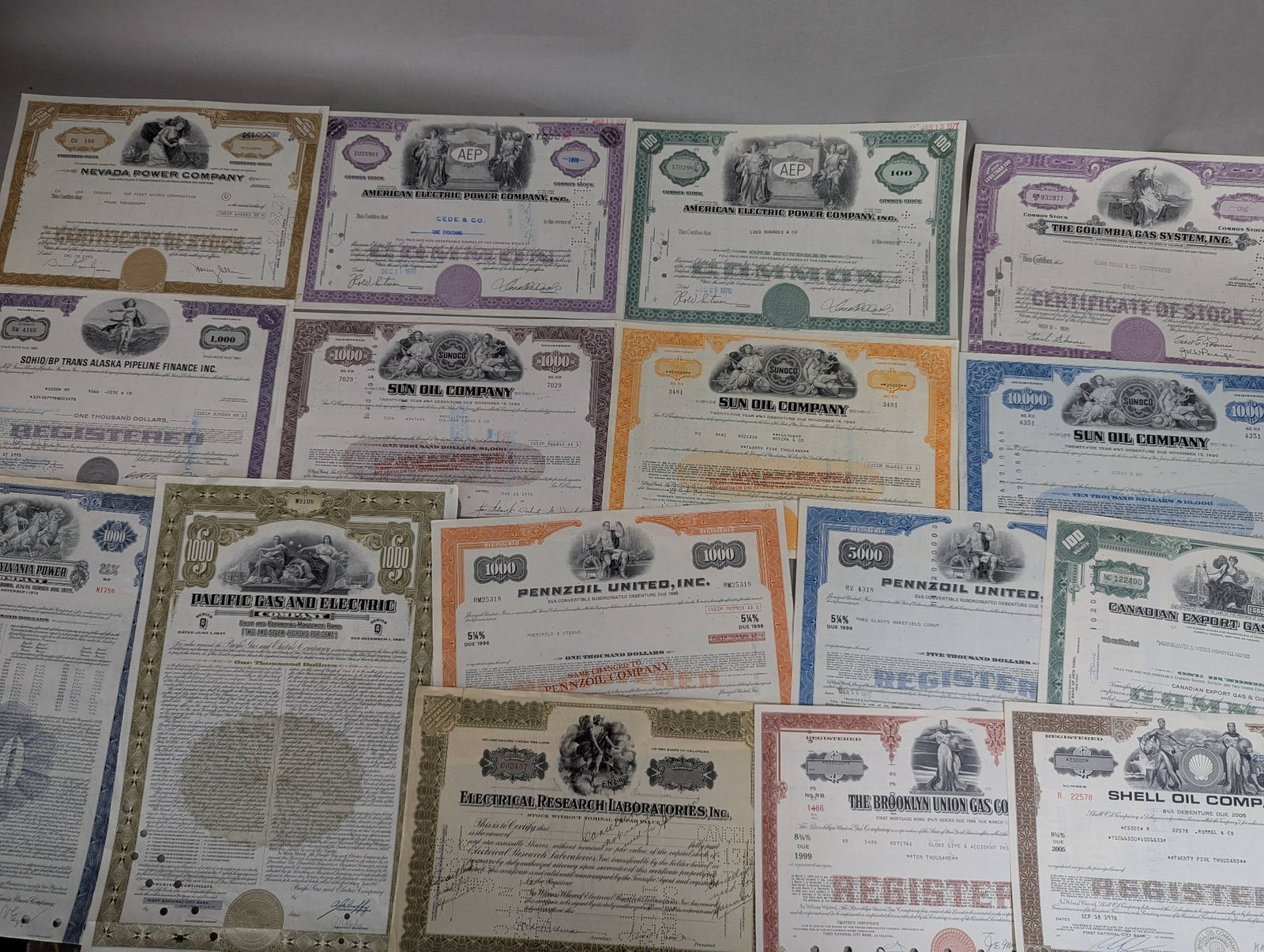 Oil and Energy Company Vintage Stock Certificates: 15 stock certificates associated with various oil and energy companies. The certificates include issuances from prominent corporations such as Sun Oil Company, Shell Oil Company, Pennzoil United Inc.,