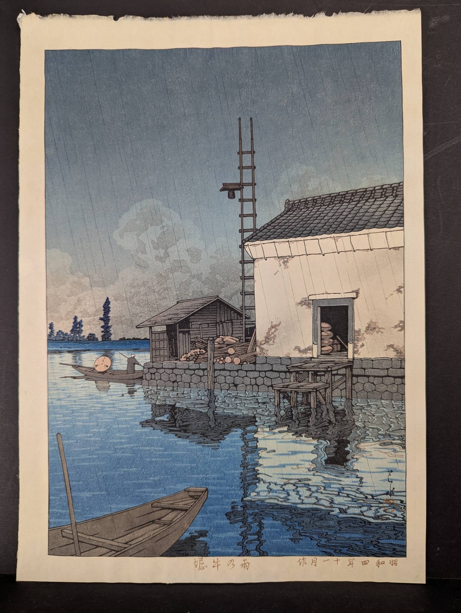 Rain at Ushibori by Kawase Hasui Japanese Woodblock Print 1929: Japanese woodblock print "Rain at Ushibori" (Ame no Ushibori) by Kawase Hasui, 1929. Print dimensions measure 12 inches high by 16 1/2 inches wide and depict a serene scene of dockhouses at Ushibori,