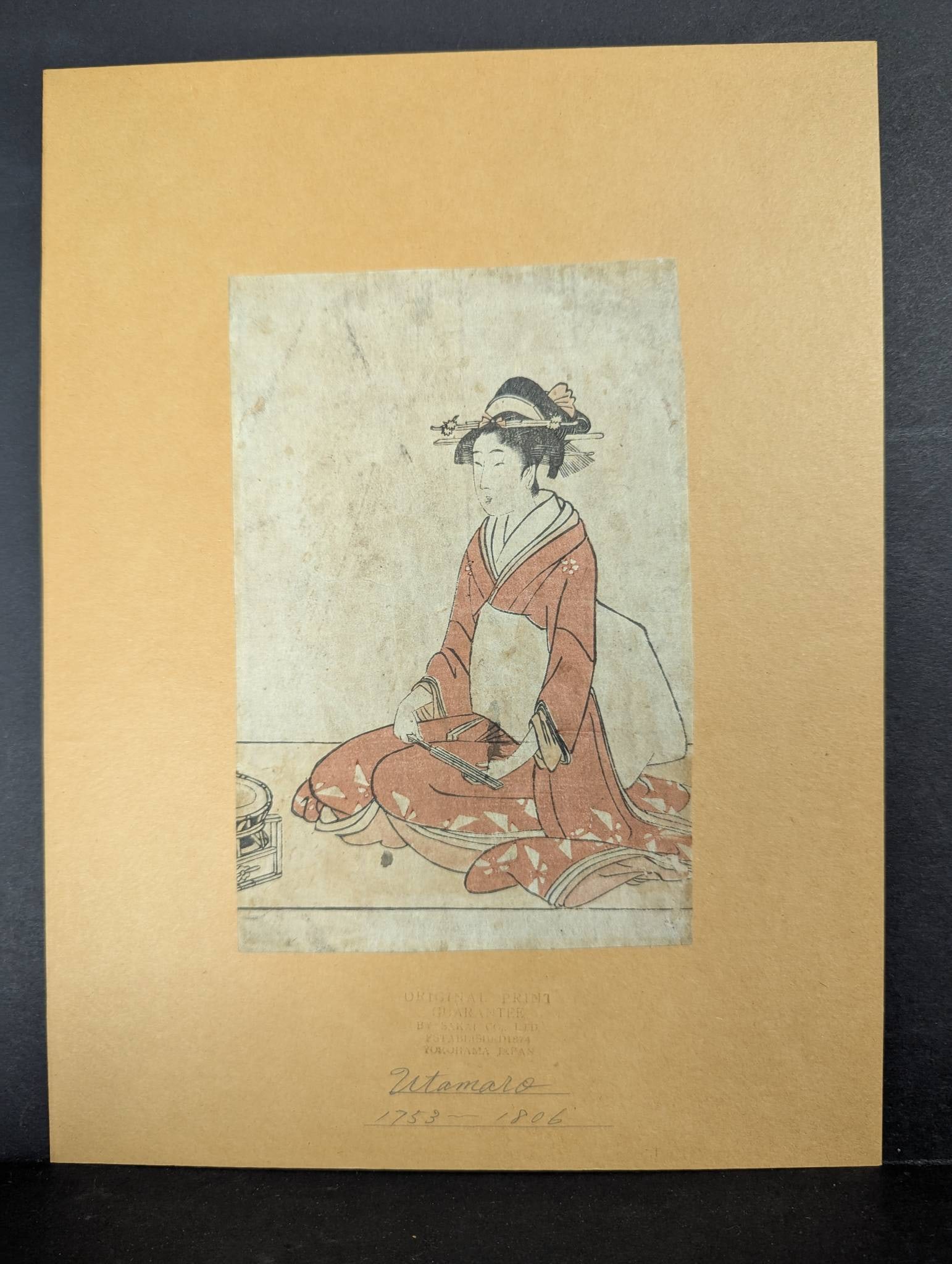 Japanese Woodblock Print by Kitagawa Utamaro Depicting Seated Woman Original 18th Century: Japanese woodblock print by Kitagawa Utamaro (1750-1806) featuring a seated woman from the 18th century. Utamaro is renowned for his portrayals of bijin-ga (beautiful women) and his innovative use of 