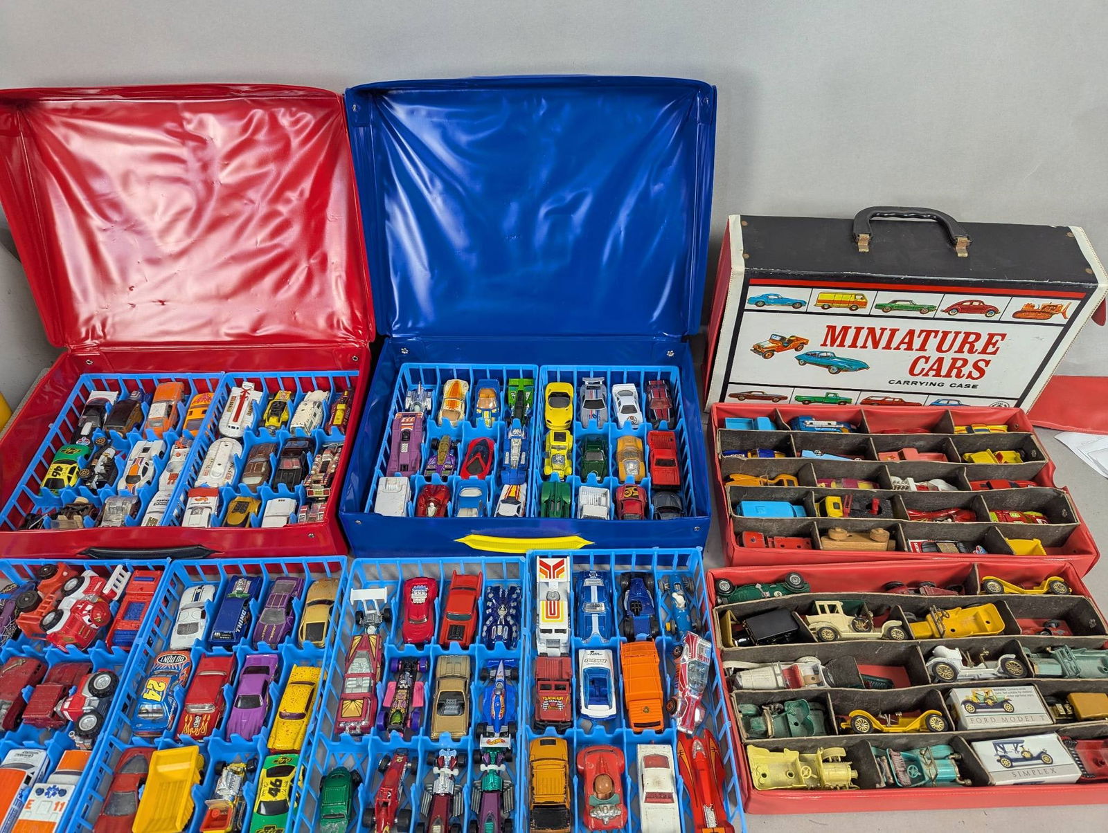 134 Matchbox Hot Wheels Die Cast Cars in Cases: 134 assorted die cast vehicles primarily from Matchbox and Hot Wheels, stored in three carrying cases. The red and blue 48-car race cases measure approximately 13 inches high, 10 inches wide, and 3 in