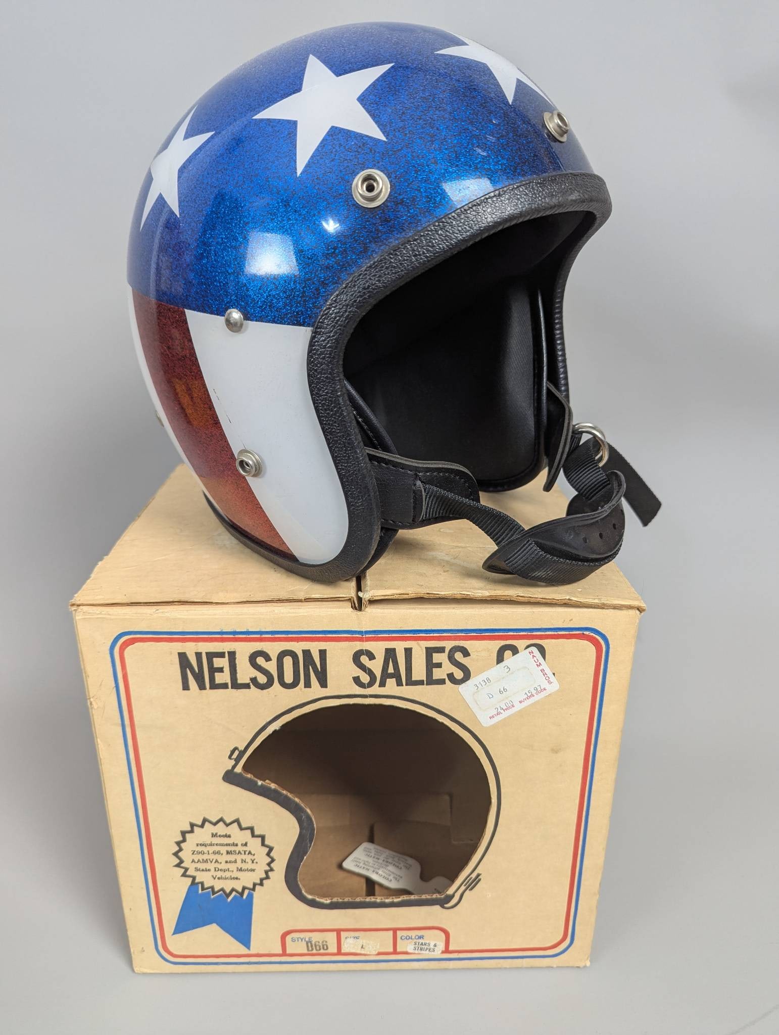 1970s Nelson Sales Co Helmet with Star and Stripe Design: Helmet manufactured by Nelson Sales Co. in the 1970s, featuring a glitter-finished blue design with white stars and red stripes. Comes in its original packaging, a 10 x 9 x 11 box, labeled by the manu