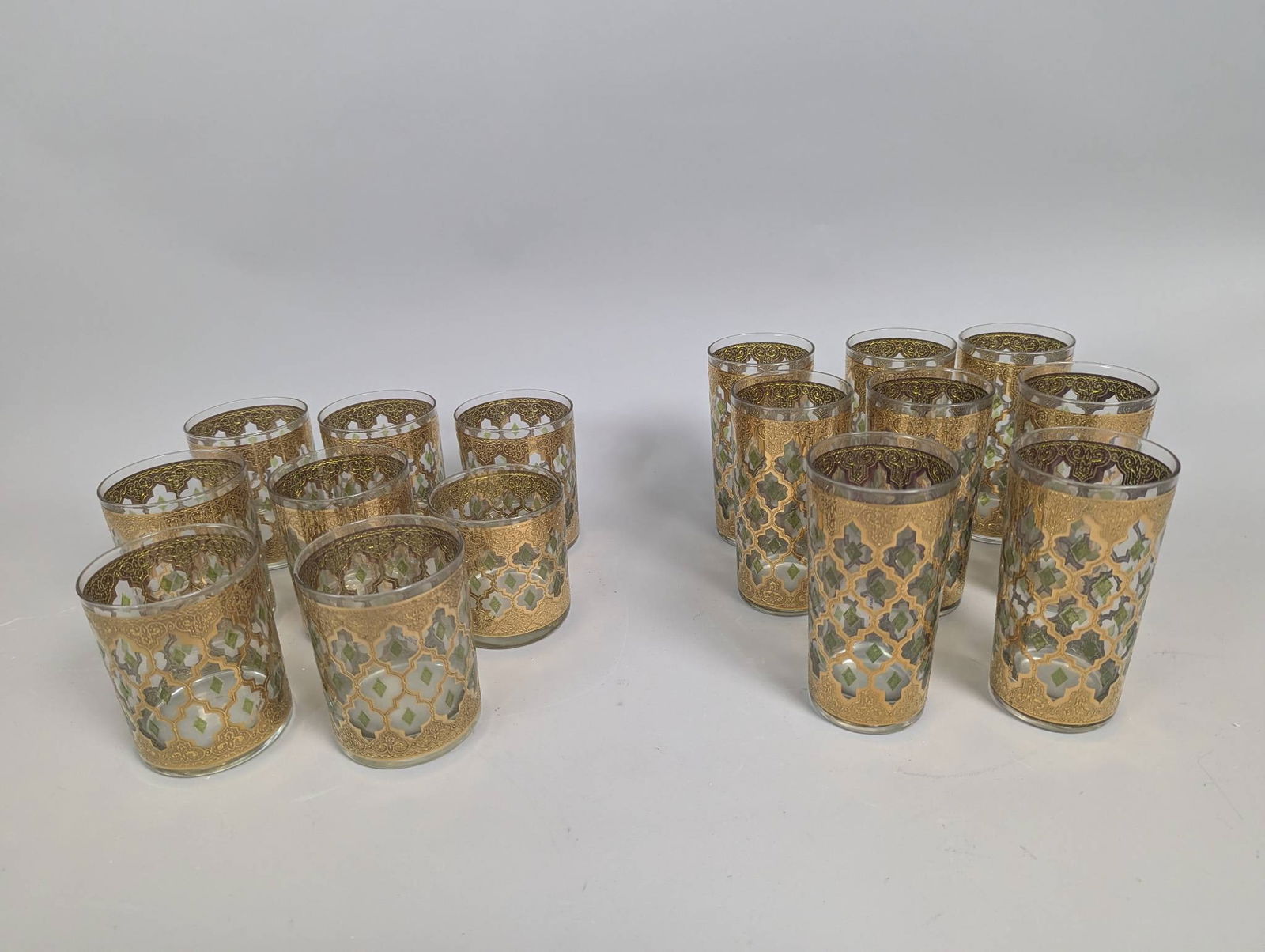 16 Culver Valencia Glassware with Mid Century Moroccan Design: 16 vintage Culver Valencia glasses, featuring a distinctive 22k gold Moroccan-style pattern with raised green diamond accents. The set consists of varying glass styles and dimensions: six glasses meas