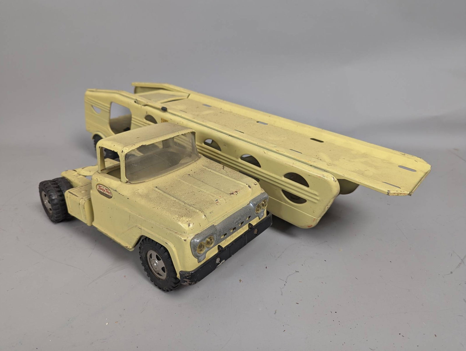 Tonka Steel Classics Car Transport Carrier in Yellow with Rugged Tires: Tonka Steel Classics Car Carrier toy in vibrant yellow, featuring rugged steel construction for enhanced durability during play. Designed with a friction-powered mechanism, it includes realistic detai