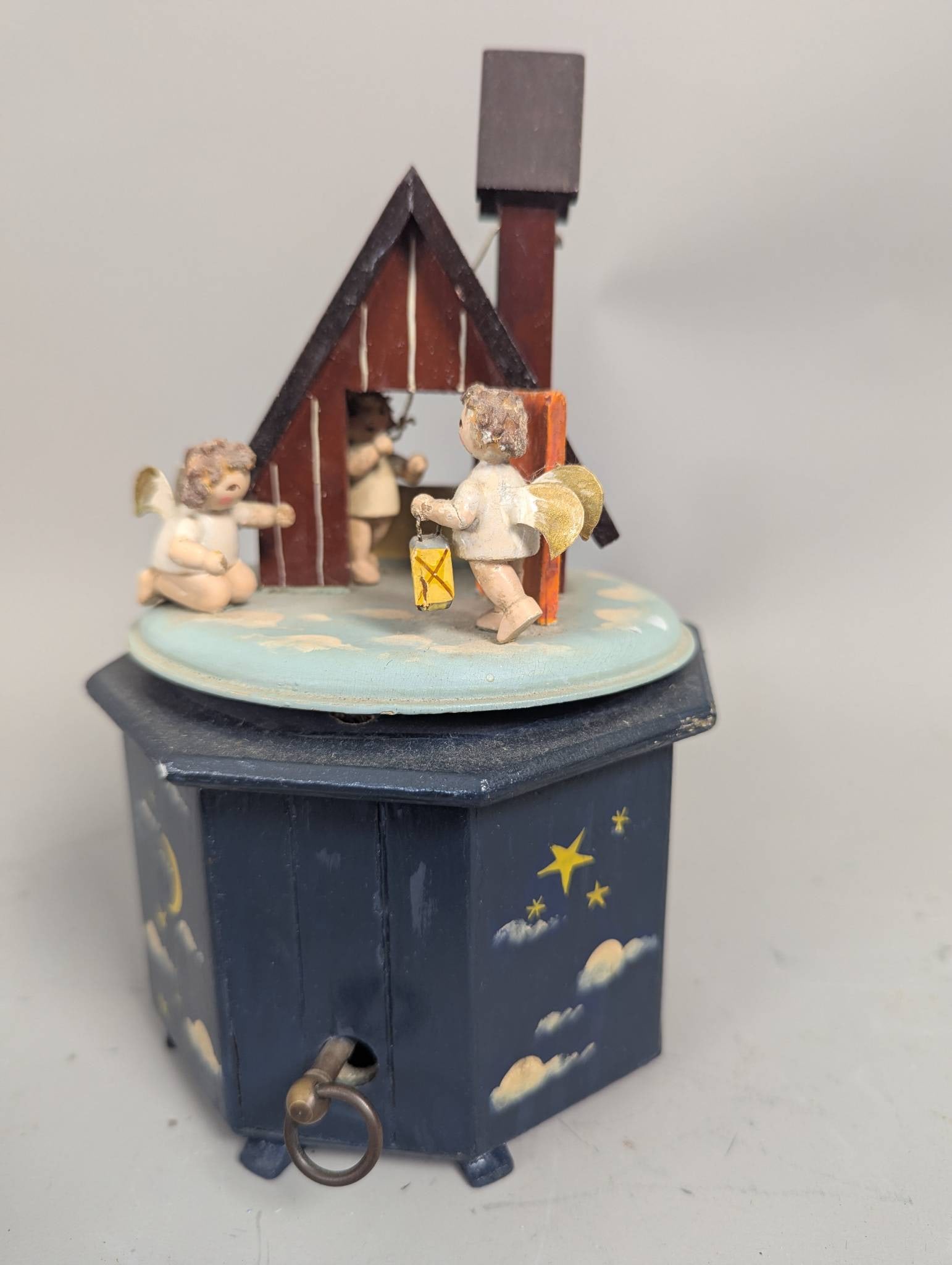 Thorens Steinbach Music Box with Cherub and House Scene: Thorens Steinbach music box featuring a cherub and house motif. This hand-cranked music box plays Ave Maria and is marked with the Thorens label and Made in Switzerland on the underside. The piece has