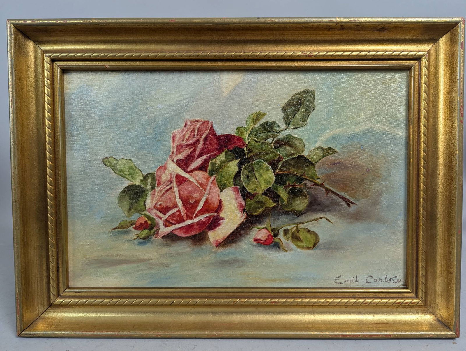 Still Life Oil Painting of Roses by Emil Carlsen: Oil painting depicting a still life composition of blooming roses with leaves on a soft pale background, signed by Emil Carlsen at the lower right. The overall dimensions, including the frame, are 19