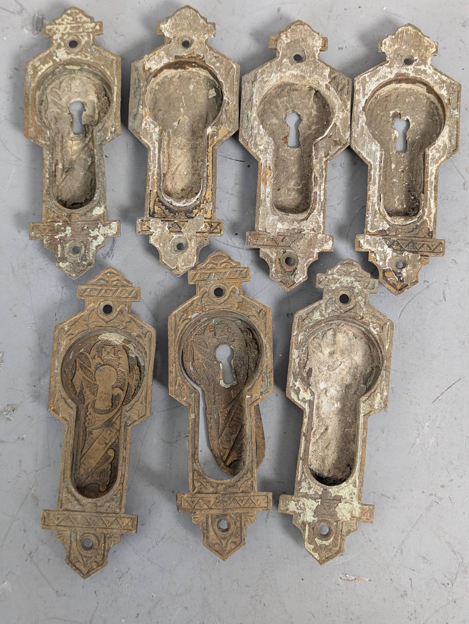 Antique Eastlake-Style Keyhole Escutcheons, Lot of 7: 7 antique Eastlake-style keyhole escutcheons from the late 19th century. Crafted in cast brass or bronze, these pieces feature the distinctive geometric and incised motifs characteristic of the Victor