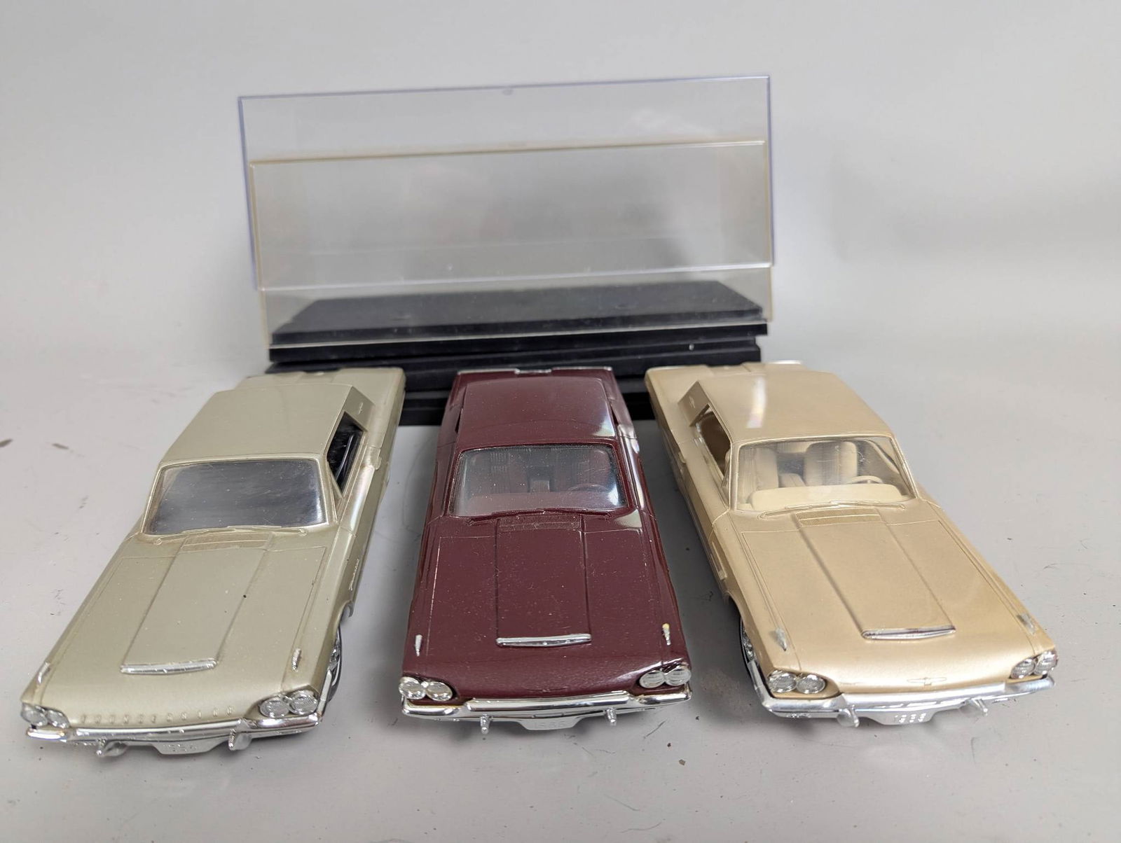 1964-1965 Ford Thunderbird Dealer Promotional Model Cars with Radio: One radio and two 1964 or 1965 Ford Thunderbird dealer promotional model cars, each housed within plastic display cases. The models are detailed representations of the Ford Thunderbird, with chrome ac
