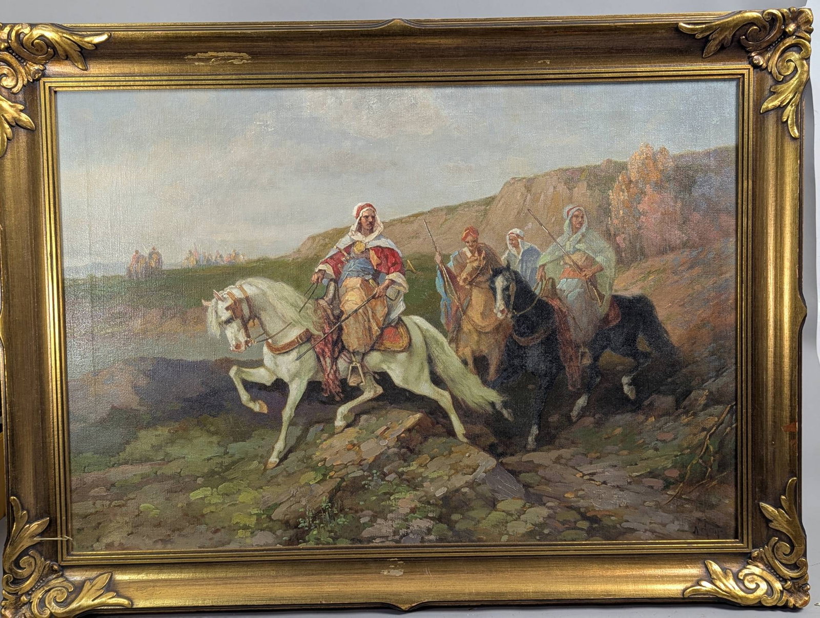 Vintage Large Oil on Canvas Depicting Arabian Horsemen: Vintage oil painting on canvas showcasing a detailed depiction of Arabian horsemen traversing a rocky path. The painting features vibrant, dynamic imagery of figures on horseback amidst a natural land