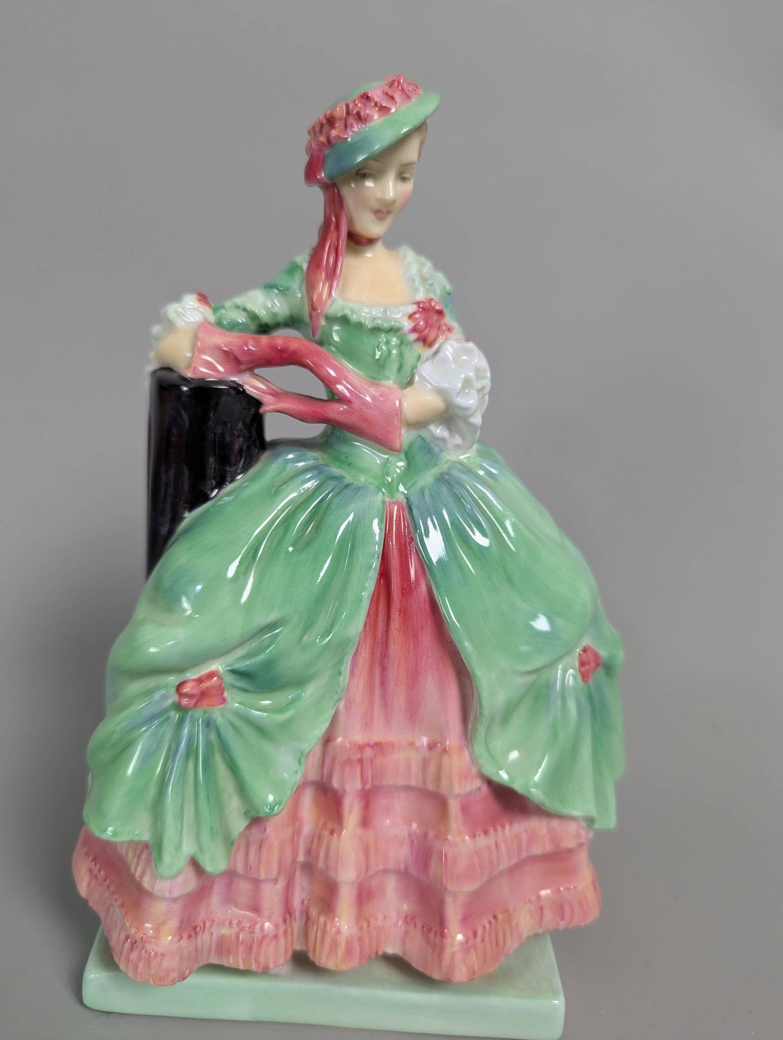 Royal Doulton HN 2028 Kate Hardcastle Figurine in Glossy Finish: Royal Doulton HN 2028 Kate Hardcastle figurine featuring a glossy finish and hand-painted pastel colors. This collectible ceramic piece, standing 8 1/2 inches high, showcases a detailed depiction of K