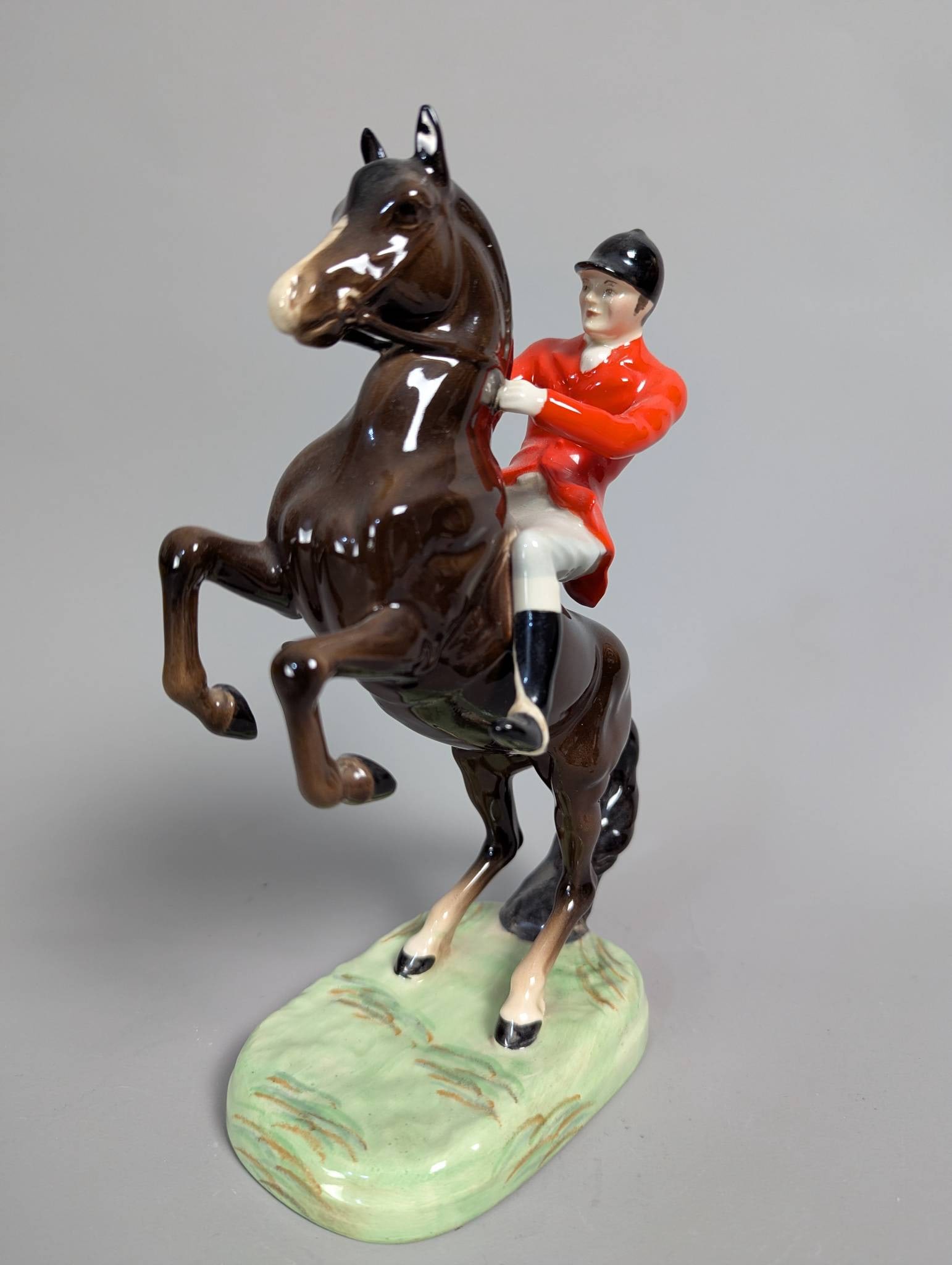 Beswick Huntsman on Rearing Horse Figurine Model 868 Designed by Arthur Gredington: Beswick Huntsman on a Rearing Horse figurine, model number 868, featuring a huntsman wearing a red coat and black hat, mounted on a brown gloss horse with an "Araby" styled head. This second version o