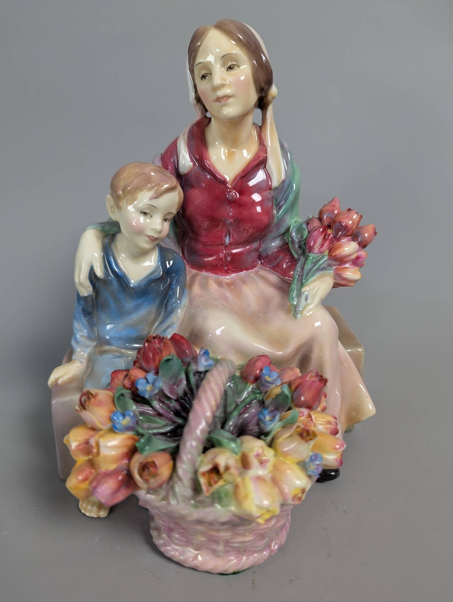 Royal Doulton HN 1641 Little Mother Hand-Painted Porcelain Figurine: Royal Doulton porcelain figurine titled Little Mother with model number HN 1641. Measuring 9 inches high, 6 1/2 inches wide, and 7 inches deep, this hand-painted sculpture depicts a seated mother and