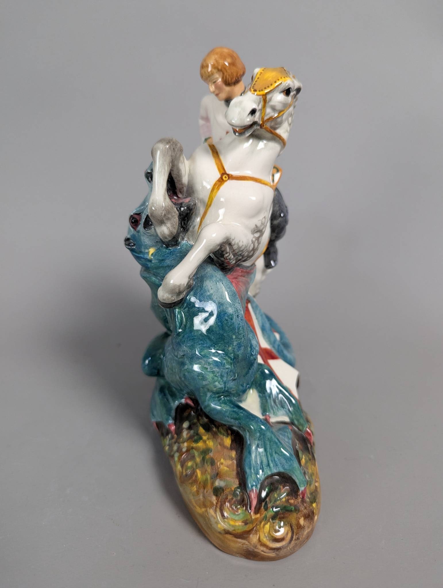 Royal Doulton HN 2051 St George Porcelain Figurine: Royal Doulton HN 2051 porcelain figurine titled St George. This finely detailed piece depicts St George slaying a dragon, featuring vibrant hand-painted colors and intricate modeling. The base bears t