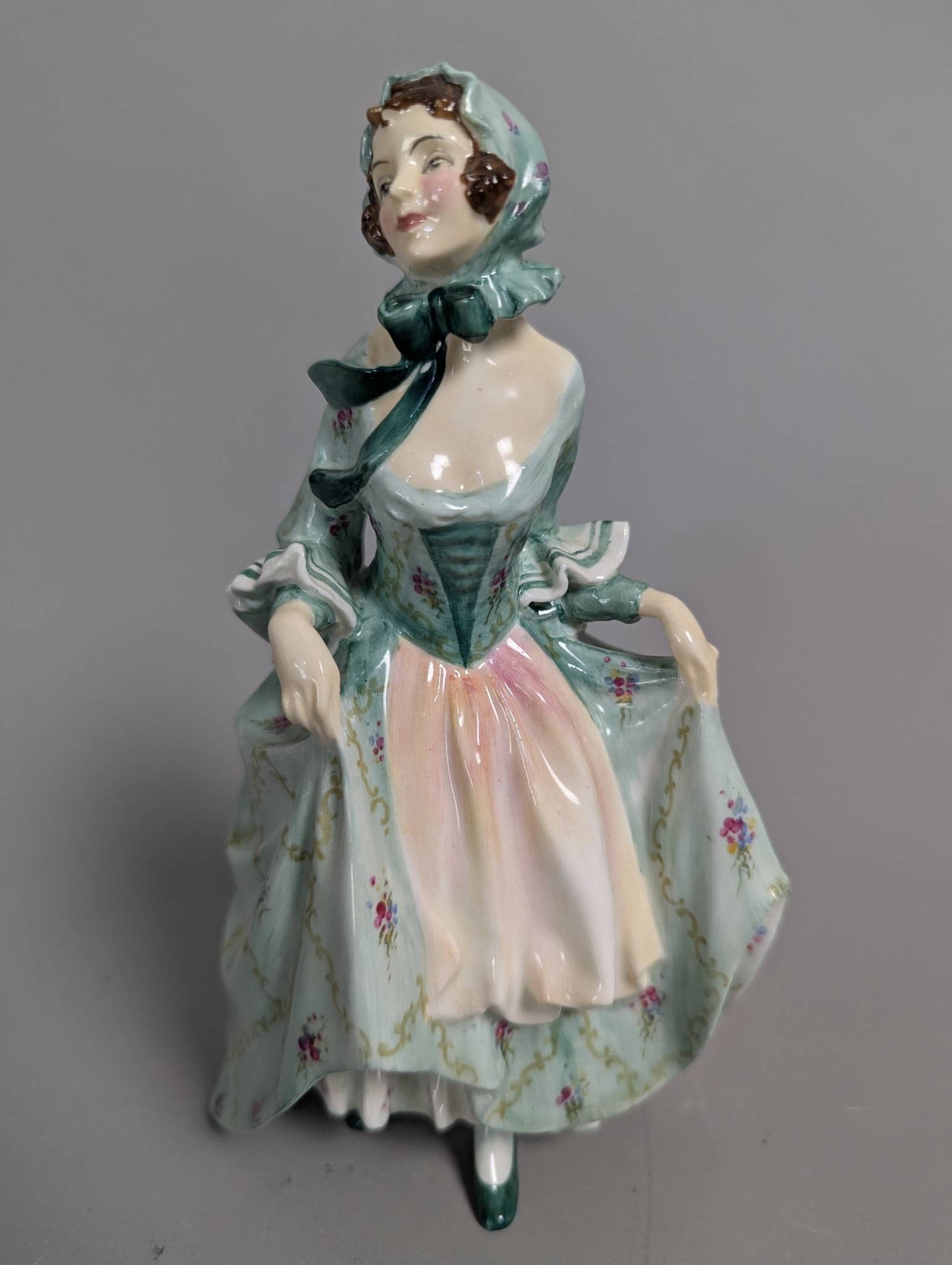 Royal Doulton HN 1690 Suzette Figure in Traditional Dress: Royal Doulton HN 1690 Suzette figure crafted from fine bone china. Standing 8 inches high, this hand-painted figurine features intricate detailing of a lady dressed in a bonnet and flowing gown with f