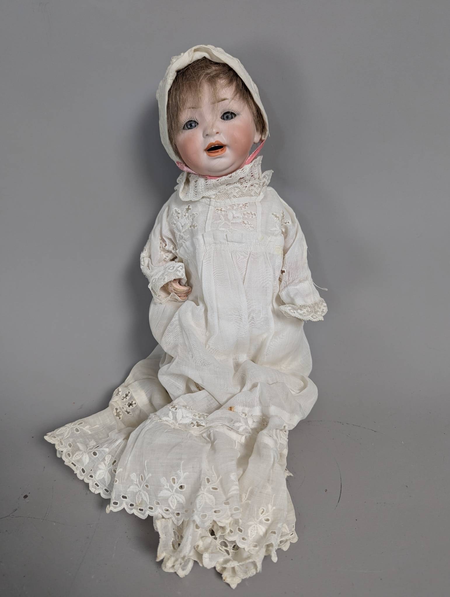 German Hertel Schwab and Co 152 Bisque Character Baby Doll in Antique Gown: A likely antique German Hertel, Schwab and Co. 152 bisque character baby doll, approximately 25 to 26 inches tall. The doll features a bisque socket head with set glass eyes, an open mouth with teeth,