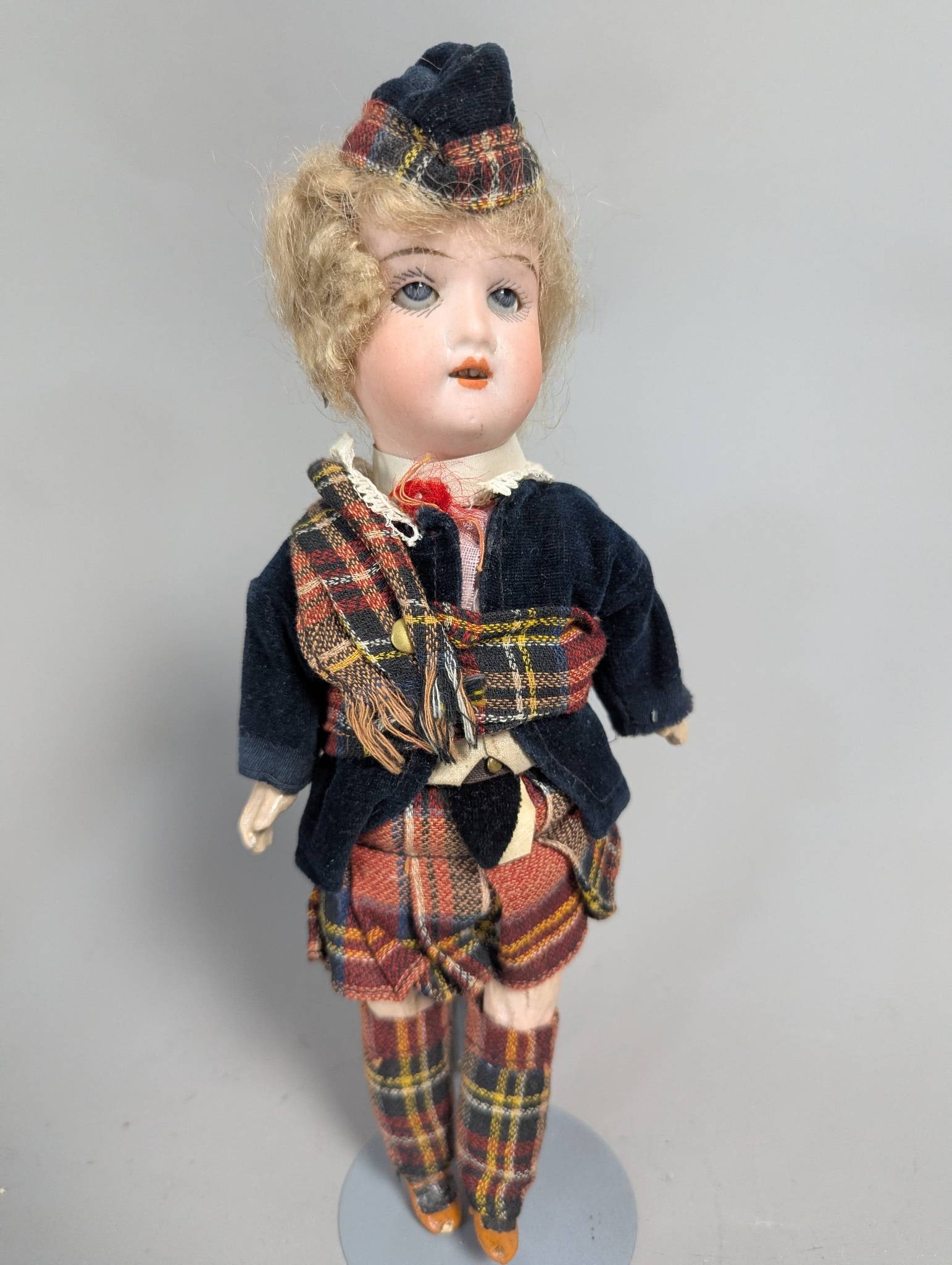Antique German Bisque-Head Doll in Traditional Scottish Attire: Antique German bisque-head doll likely dating to the early 20th century, possibly made by J. Walther & Sohn or Armand Marseille. The doll stands 10 inches high and features a bisque socket head with g