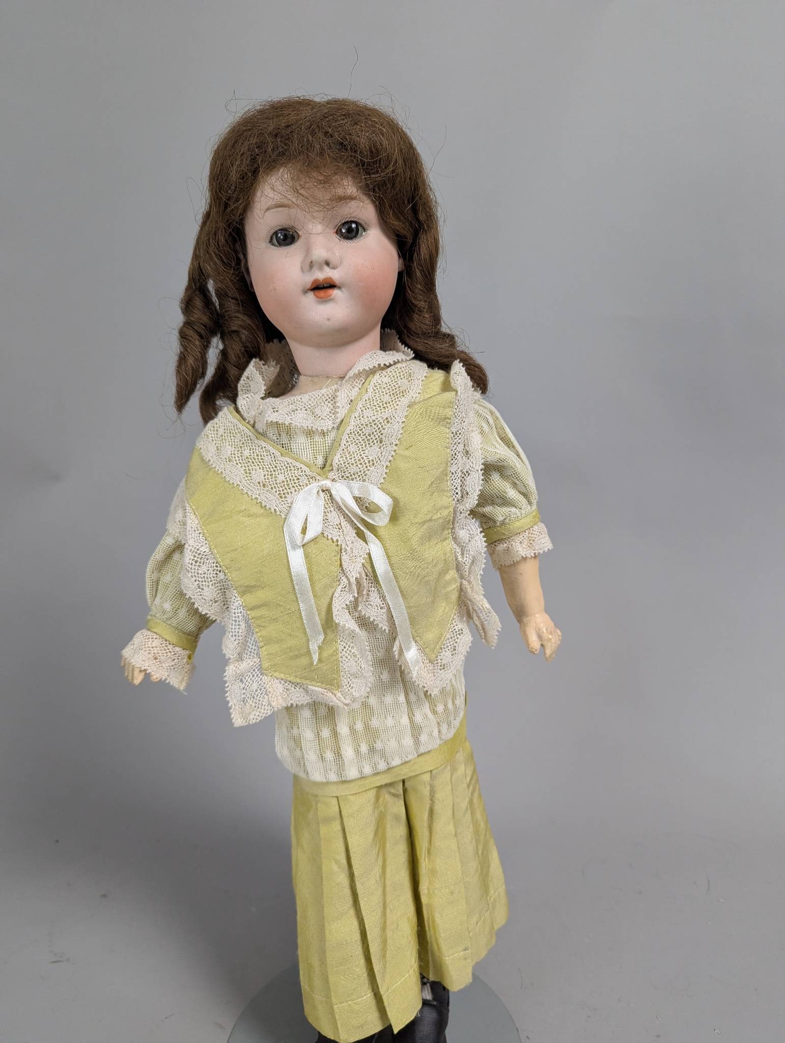 19 High Simon and Halbig Doll with Bisque Head and Composite Body: Simon and Halbig doll measuring 19 inches high, featuring a bisque head and a composite body. Markings on the back of the head include Made in Germany and the Simon and Halbig logo. The doll showcases