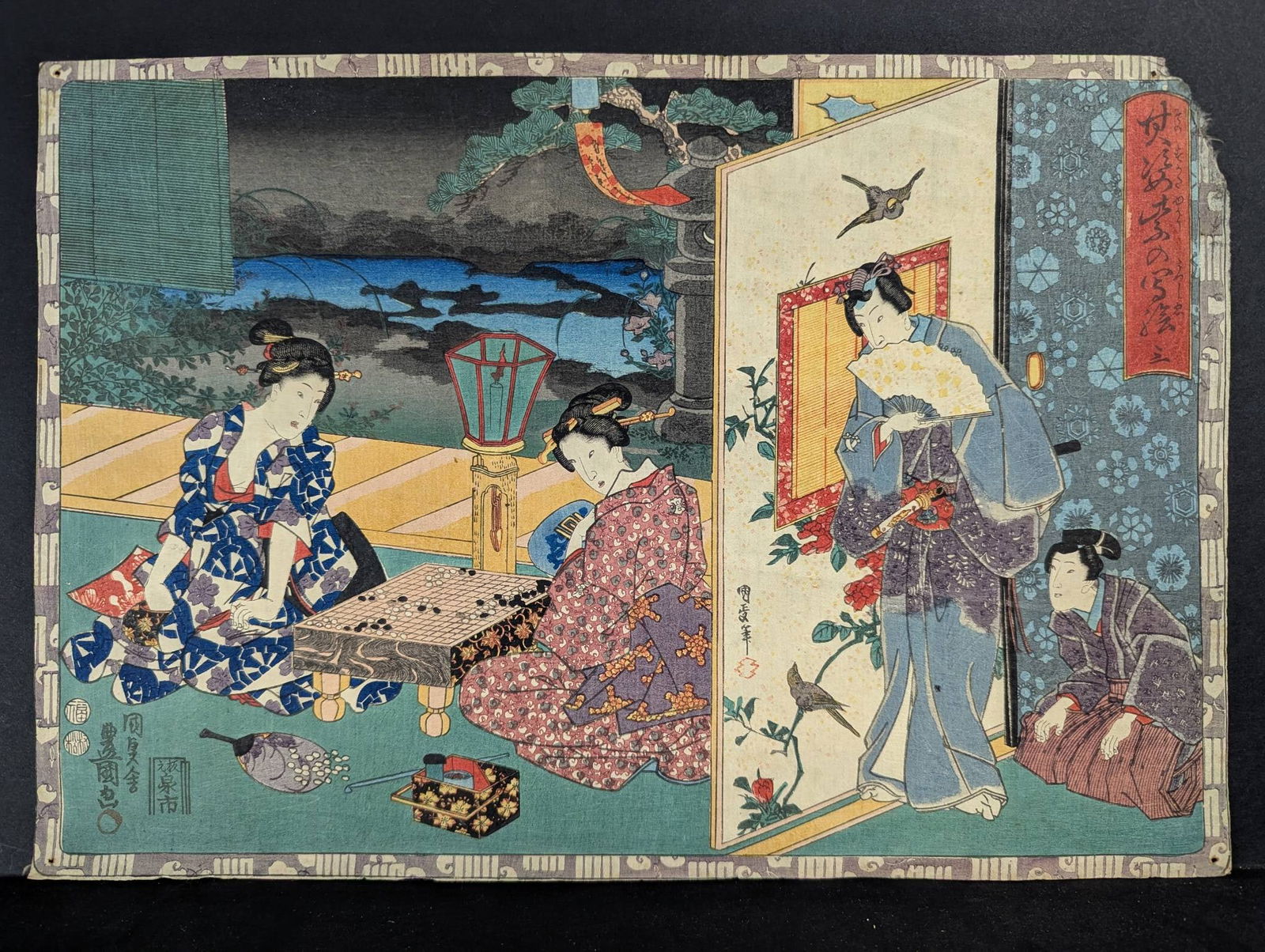 Japanese Woodblock Print By Utagawa Toyokuni III Depicting Domestic Scene Original 19th Century: A Japanese woodblock print by Utagawa Toyokuni III (1786-1875). This vibrant scene captures a group of figures involved in domestic activities, including playing a board game and fanning oneself indoo