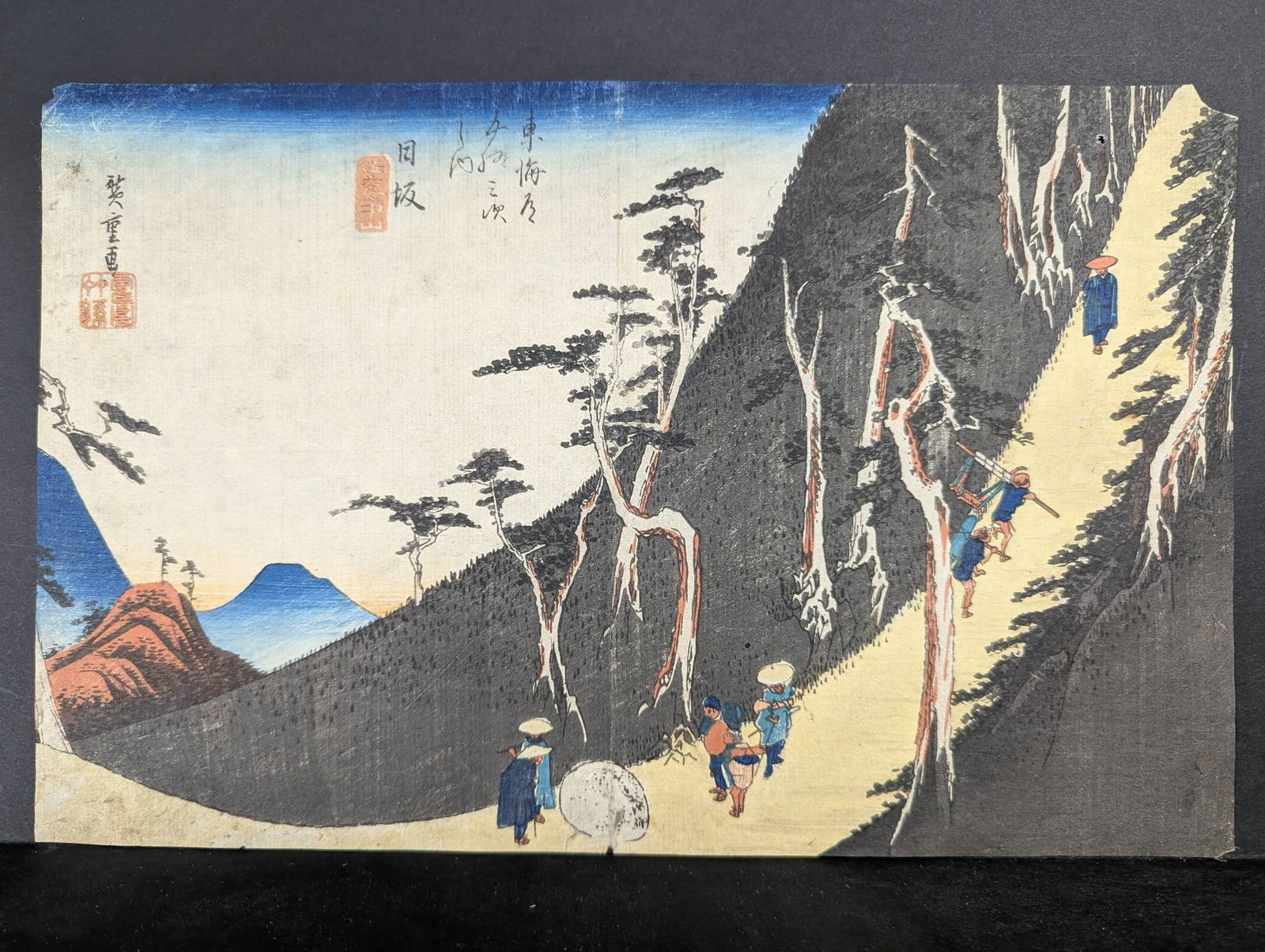 Japanese Woodblock Print by Ando Hiroshige Depicting Nissaka Original 19th Century: Japanese woodblock print by renowned artist Ando Hiroshige (1797-1858), titled Nissaka from the Hoeido Tokaido series, created in 1833. The print showcases a scenic pathway through mountains with trav
