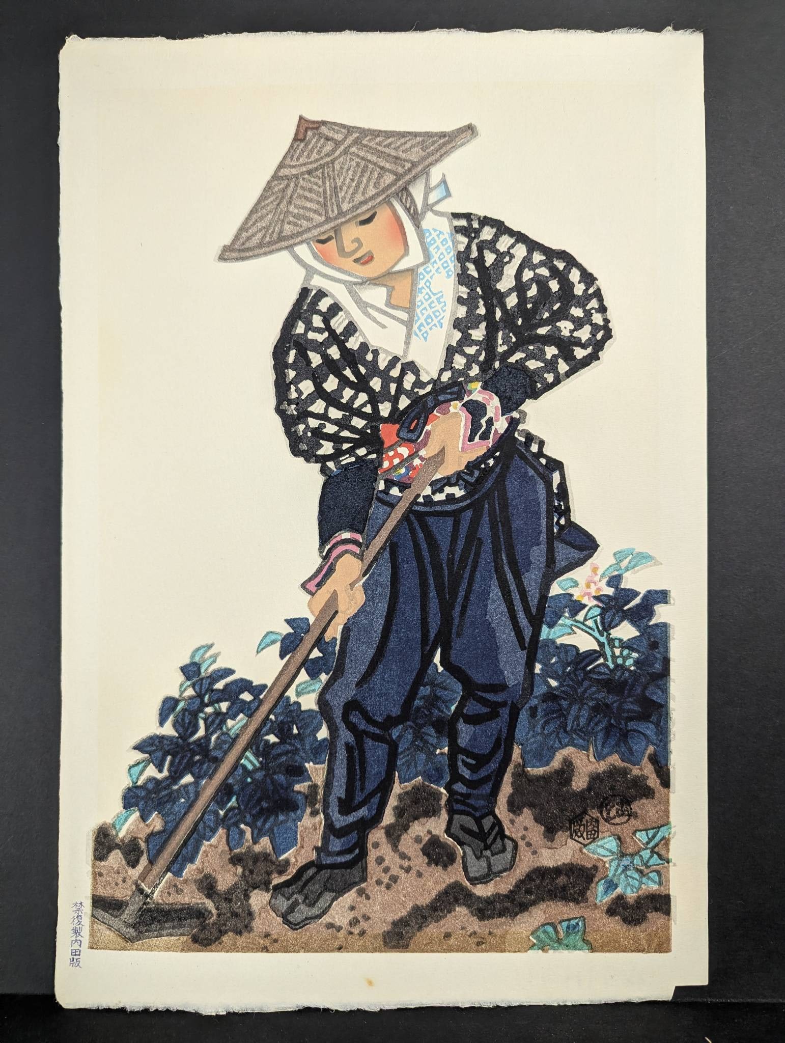 Japanese Woodblock Print Depicting Farmer in Kyoto by Eiichi Kotozuka: Woodblock print titled Farmer in Kyoto by Japanese artist Eiichi Kotozuka (1906-1979). Created circa 1950, it depicts a traditional scene of a farmer in patterned attire working the soil. The print sh