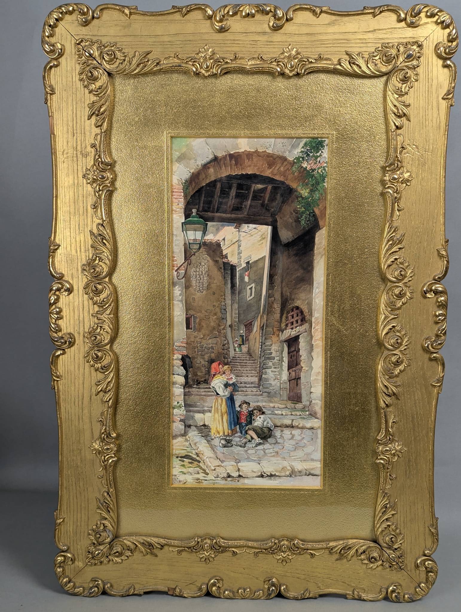 Watercolor by Pietro Pavesi Depicting a Italian Village Scene in Ornate Frame: Watercolor painting by Italian artist Pietro Pavesi (1844-1907). The artwork depicts a village scene with a woman, children, and a cobblestone pathway leading to steps and buildings, characterized by