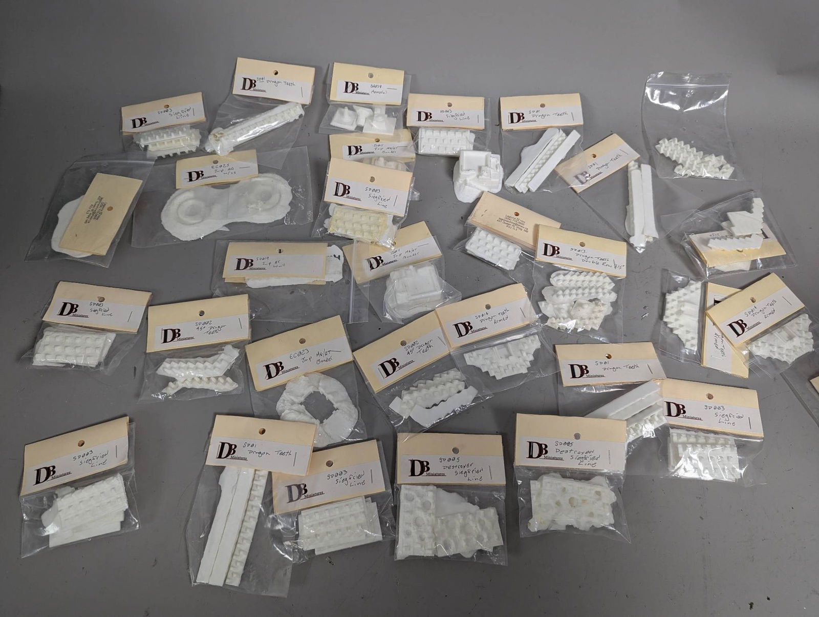 New Old Stock WWII Plastic Miniatures by DB Miniatures: New old stock plastic miniatures by DB Miniatures, themed on WWII. Includes multiple unassembled pieces in individually packaged plastic bags. Items are labeled with various designations such as