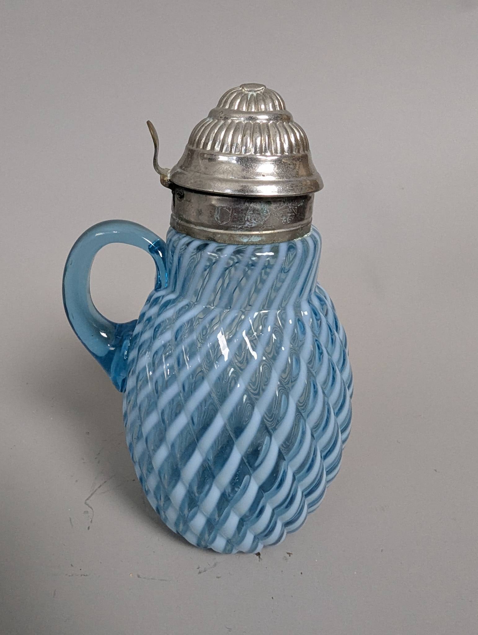 Antique Blue Opalescent Glass Syrup Pitcher in Buckeye Reverse Swirl Pattern: Antique blue opalescent glass syrup pitcher crafted by Buckeye Glass Co. around the late 19th century, circa 1890. This piece showcases the Buckeye Reverse Swirl pattern, distinguished by its