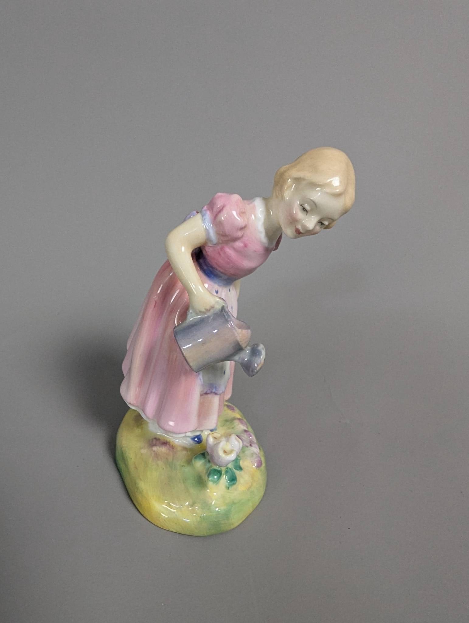 Royal Doulton Figurine HN2044 Mary Mary in Pink Dress: Royal Doulton hand-painted porcelain figurine HN2044, titled Mary Mary. This piece depicts a young girl watering flowers, dressed in a pink and white dress with a blue bow. The figure is marked on the