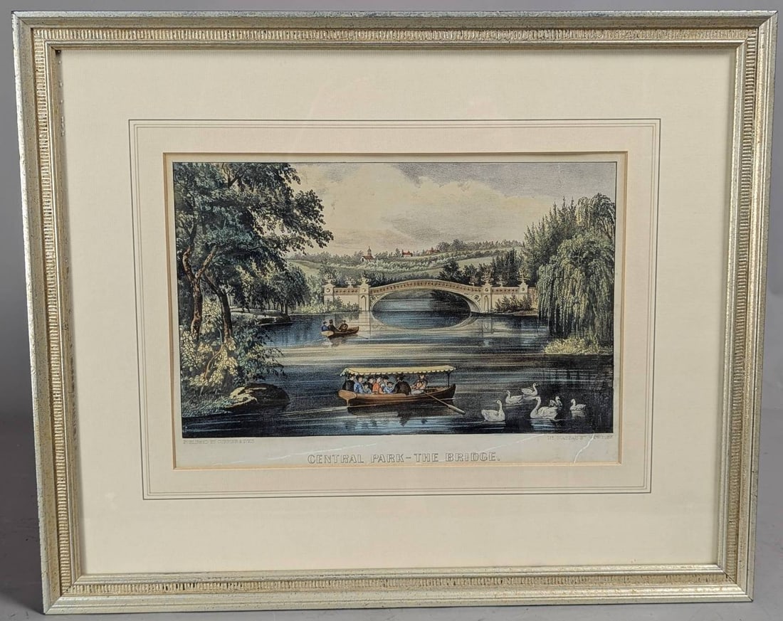 Lithograph Published by Currier and Ives Depicting Central Park Bridge Scene: Hand-colored lithograph published by Currier and Ives titled Central Park - The Bridge. Depicts a serene outdoor view of a lake in Central Park, showcasing a bridge in the background, rowing boats wit
