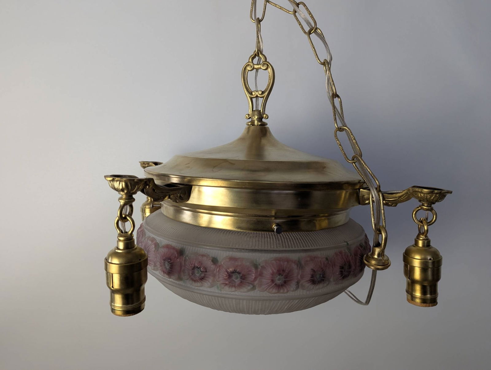 1920s Brass Pan-Style Chandelier with Hand-Painted Rose Glass Shades: Vintage 1920s brass pan-style chandelier featuring a polished brass fixture with four lights. The glass shades are hand-painted on the inside with pink roses and green leaves set against a white backg