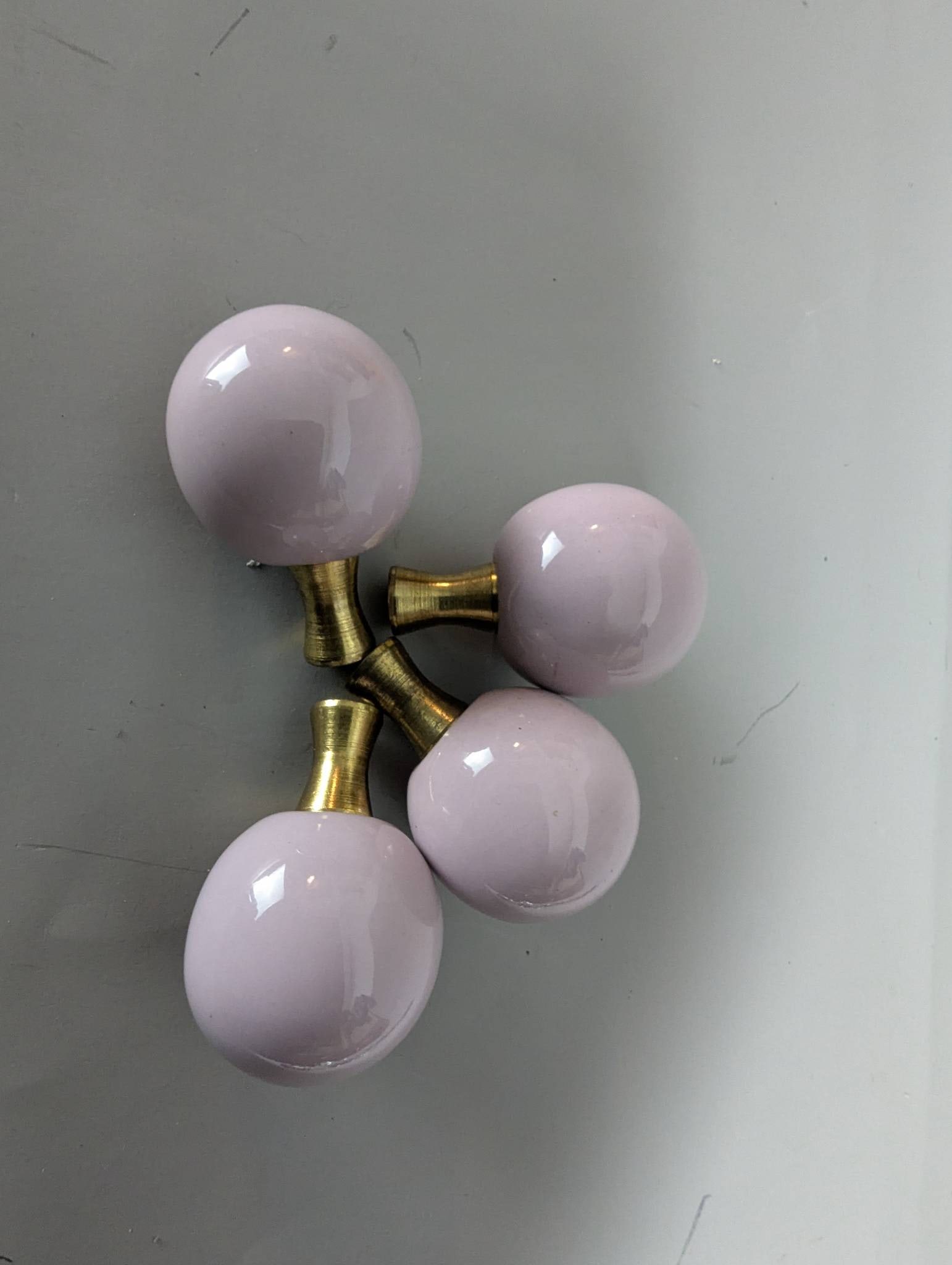Pink Ceramic Ball Lamp Finials with Brass Base, Set of 4: 4 pink ceramic ball lamp finials featuring a glossy finish and brass bases. Each finial measures 2 high by 1 3/8 wide and deep. Perfect for use as decorative accents to enhance the appearance of