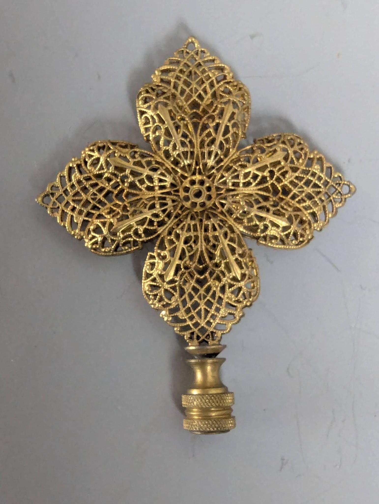 Brass Flower Filigree Decorative Lamp Finial: Brass flower filigree lamp finial with intricate openwork design and aged finish. Measures 4 1/2 inches high, 3 1/2 inches wide, and 1/2 inch deep. Designed to fit standard lamp harps, this decorative