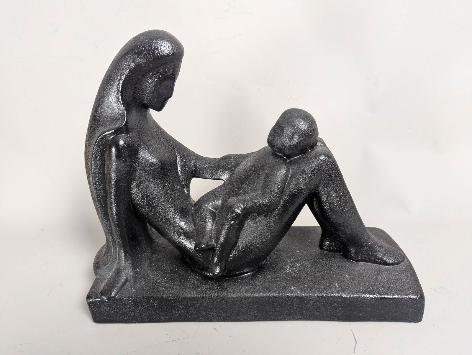 Royal Haeger Reclining Mother and Child Sculpture: Royal Haeger sculpture titled Reclining Mother and Child. This art piece portrays a serene mother reclining with her child resting upon her legs. The work measures 12 high x 5 1/4 wide x 14 deep. The