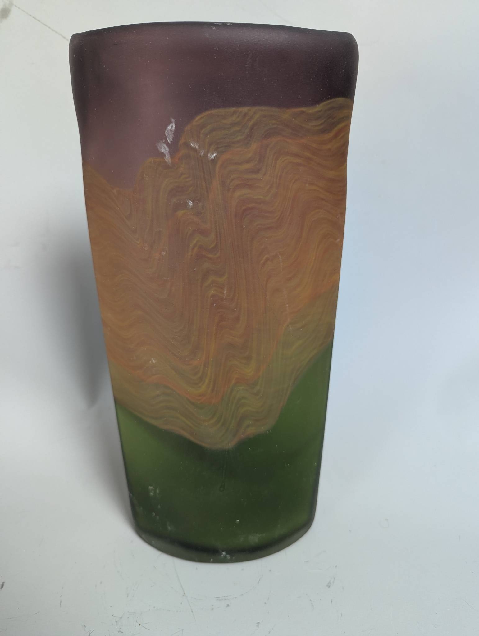 Hand Blown Multicolored Glass Vase with Abstract Design: Hand blown glass vase measuring 13 1/2 inches high x 4 inches wide x 6 1/2 inches deep. The vase features an abstract design with a blend of purple, orange, and green tones, showcasing swirls and orga