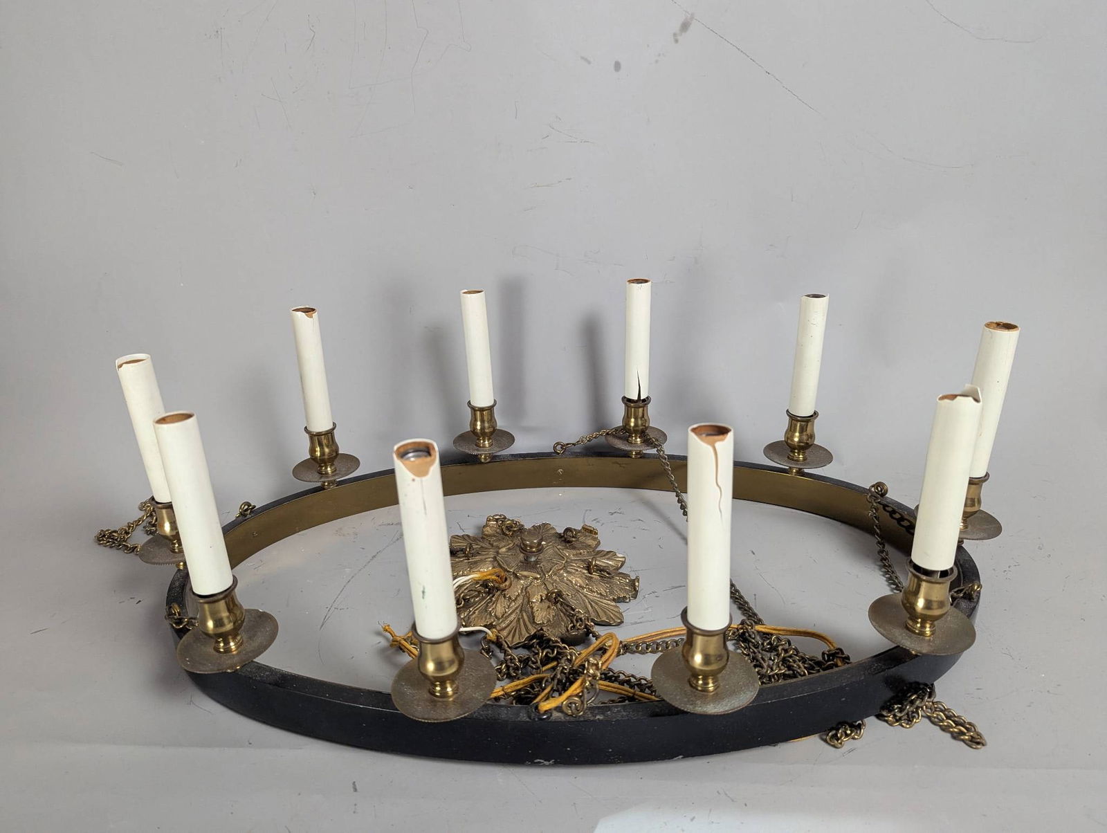 Oval Spanish Revival Chandelier with Eight Candle Holders: Oval Spanish Revival style chandelier featuring eight candle holders arranged around a metal frame. The chandelier is constructed with a combination of brass and metal, with decorative elements