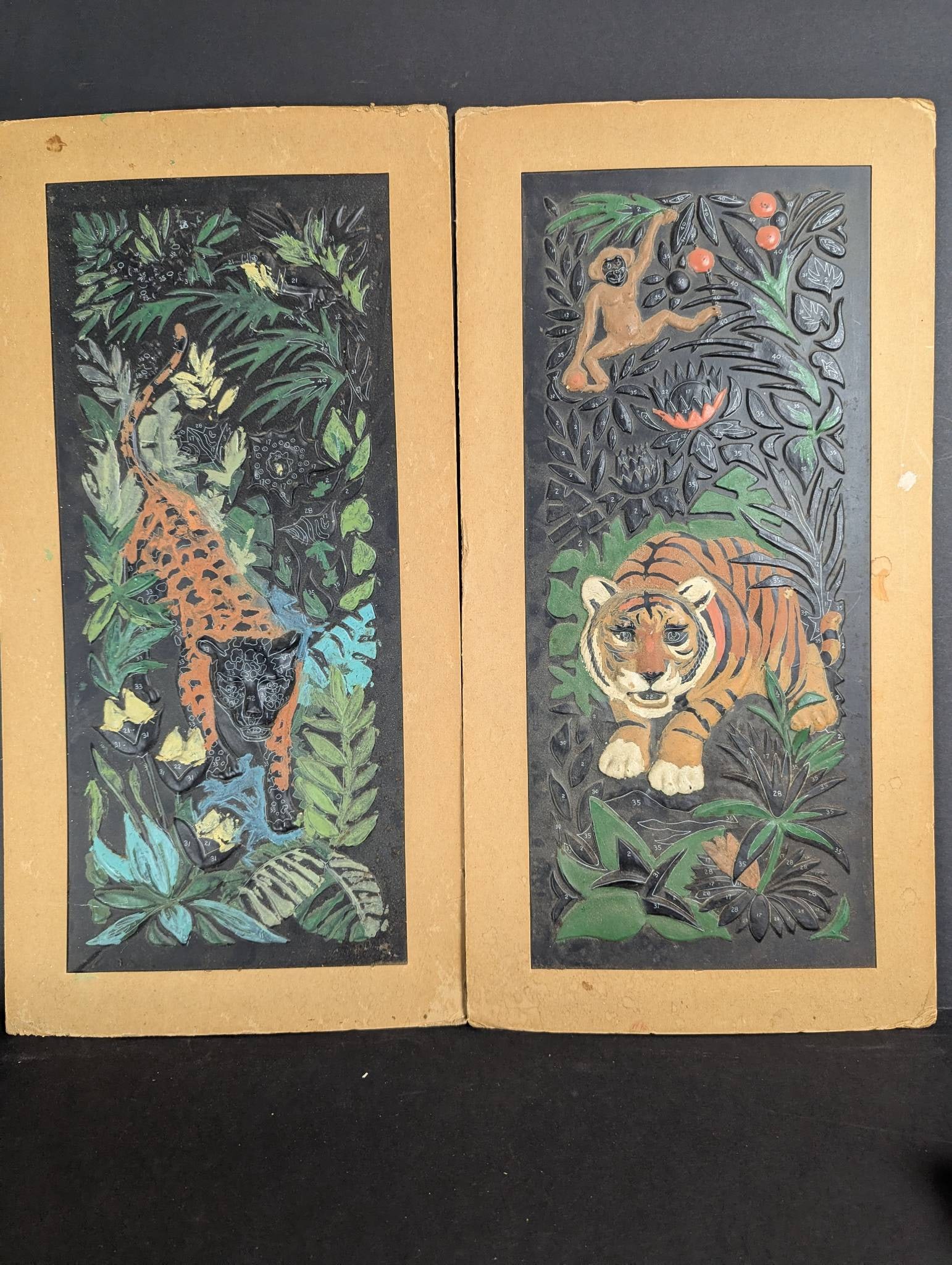 1970s Relief Plastic Paint by Number Jungle Scenes: Partially painted relief plastic paint by number artworks featuring jungle scenes. Created circa 1970s, these pieces depict a tiger, a leopard, and tropical foliage. Dimensions are approximately 11 in