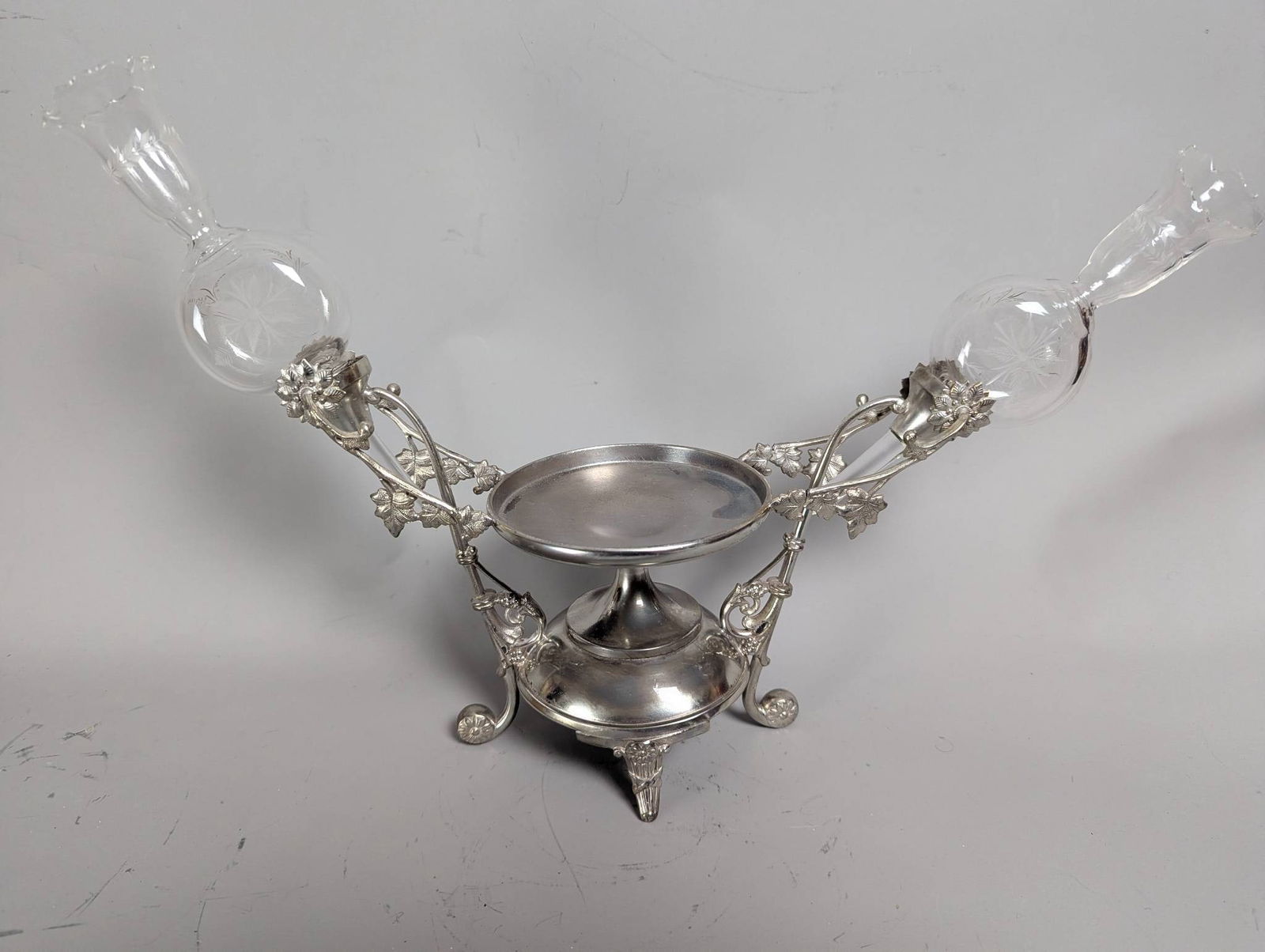Silver Plate Epergne with Glass Inserts: **Important** Please read below description on how to avoid high shipping costs. Silver plate epergne measuring 11 inches high by 18 inches wide and 5 inches deep. The piece features an ornate silver