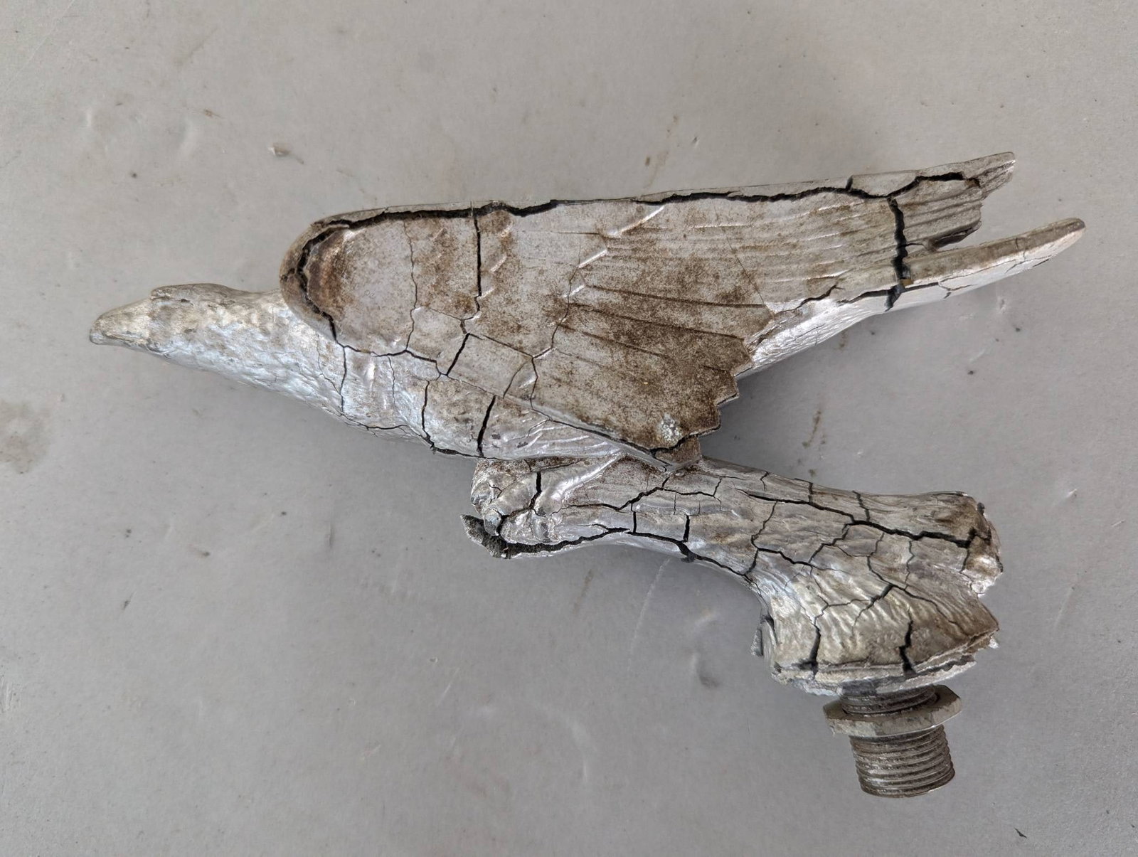 Metal Eagle Bird Hood Ornament with Threaded Base: **Important** Please read below description on how to avoid high shipping costs. A metal bird-shaped hood ornament featuring detailed wing and feather designs. The piece measures approximately 7 inche