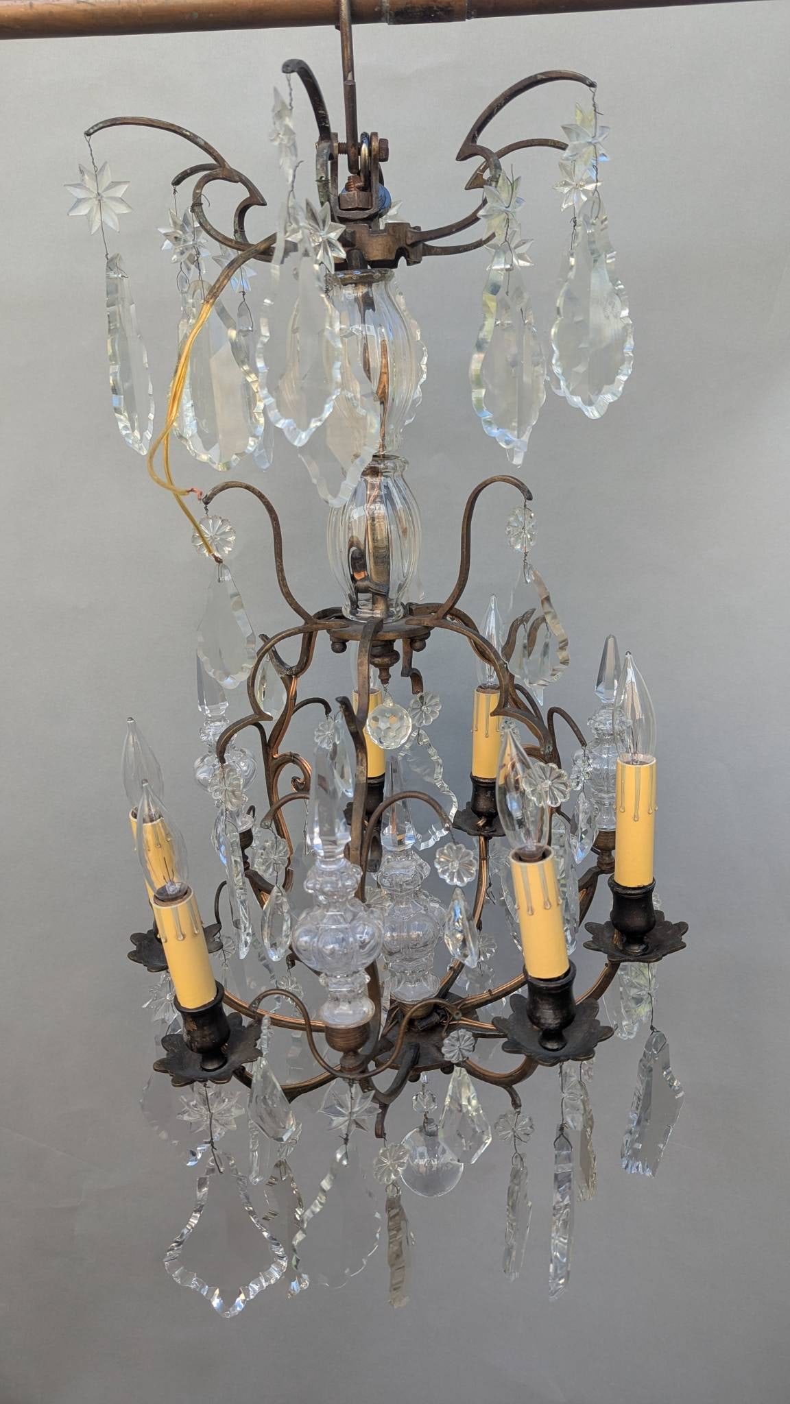 French Gilded Chandelier with Crystal Pendants and Candle-style Bulbs: **Important** Please read below description on how to avoid high shipping costs. French gilded chandelier featuring elegantly scrolled metal arms adorned with hanging crystal pendants. Equipped with s