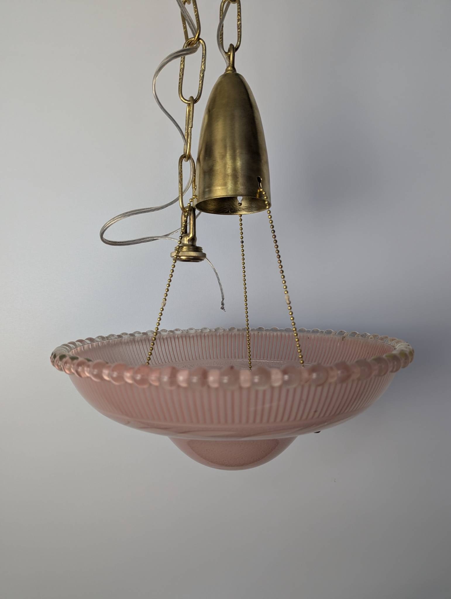 Pink Ribbed Glass Pendant Light with Brass Hardware: **Important** Please read below description on how to avoid high shipping costs. Pendant light featuring a pink ribbed glass dome-shaped shade with a beaded edge and etched foliage decoration. The