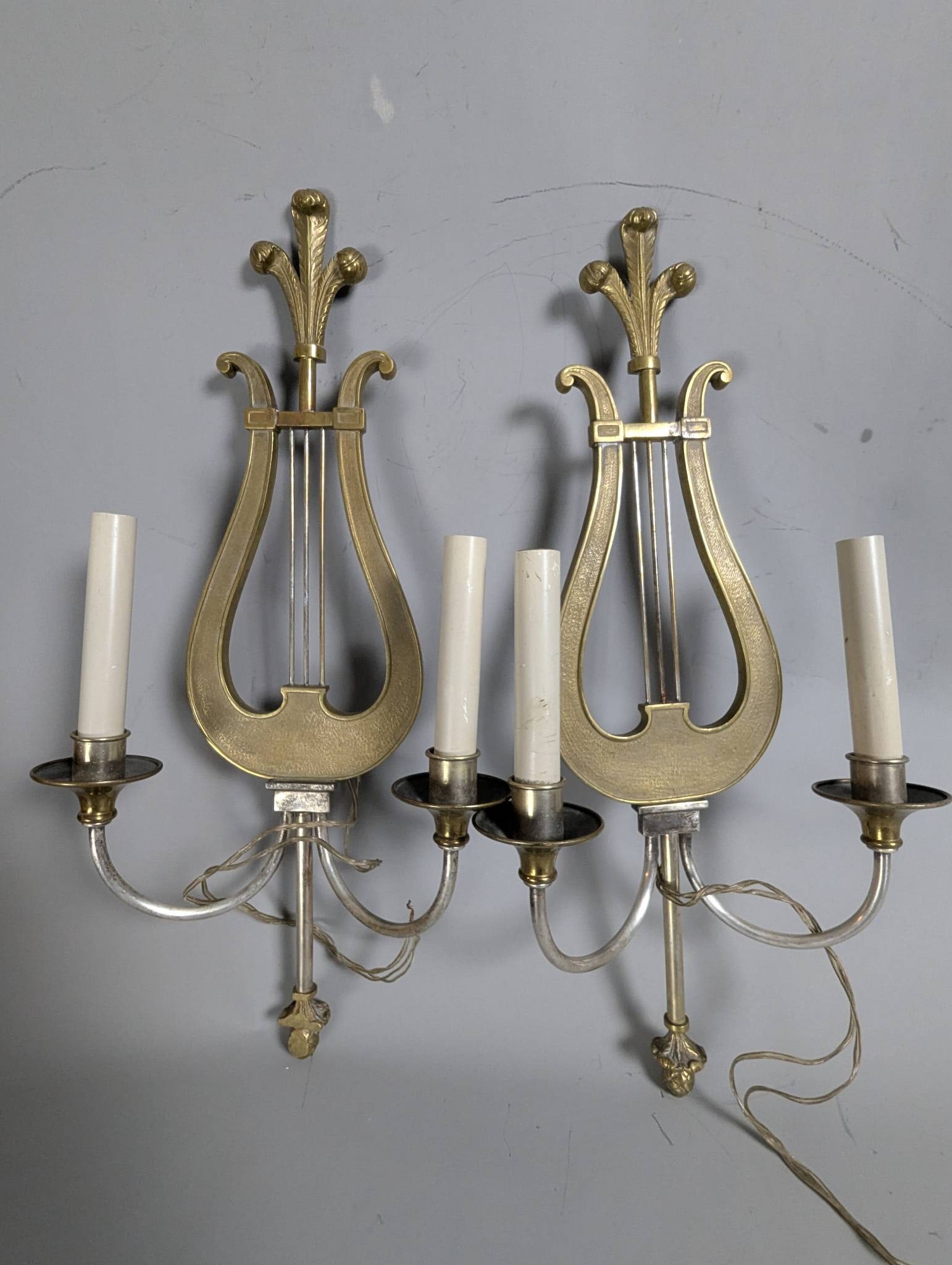 Brass Lyre-Shaped Wall Sconces in Neoclassical Style: **Important** Please read below description on how to avoid high shipping costs. Lyre-shaped brass wall sconces in the Neoclassical style, likely vintage or antique. Each measures 21 high, 10 1/2 wide