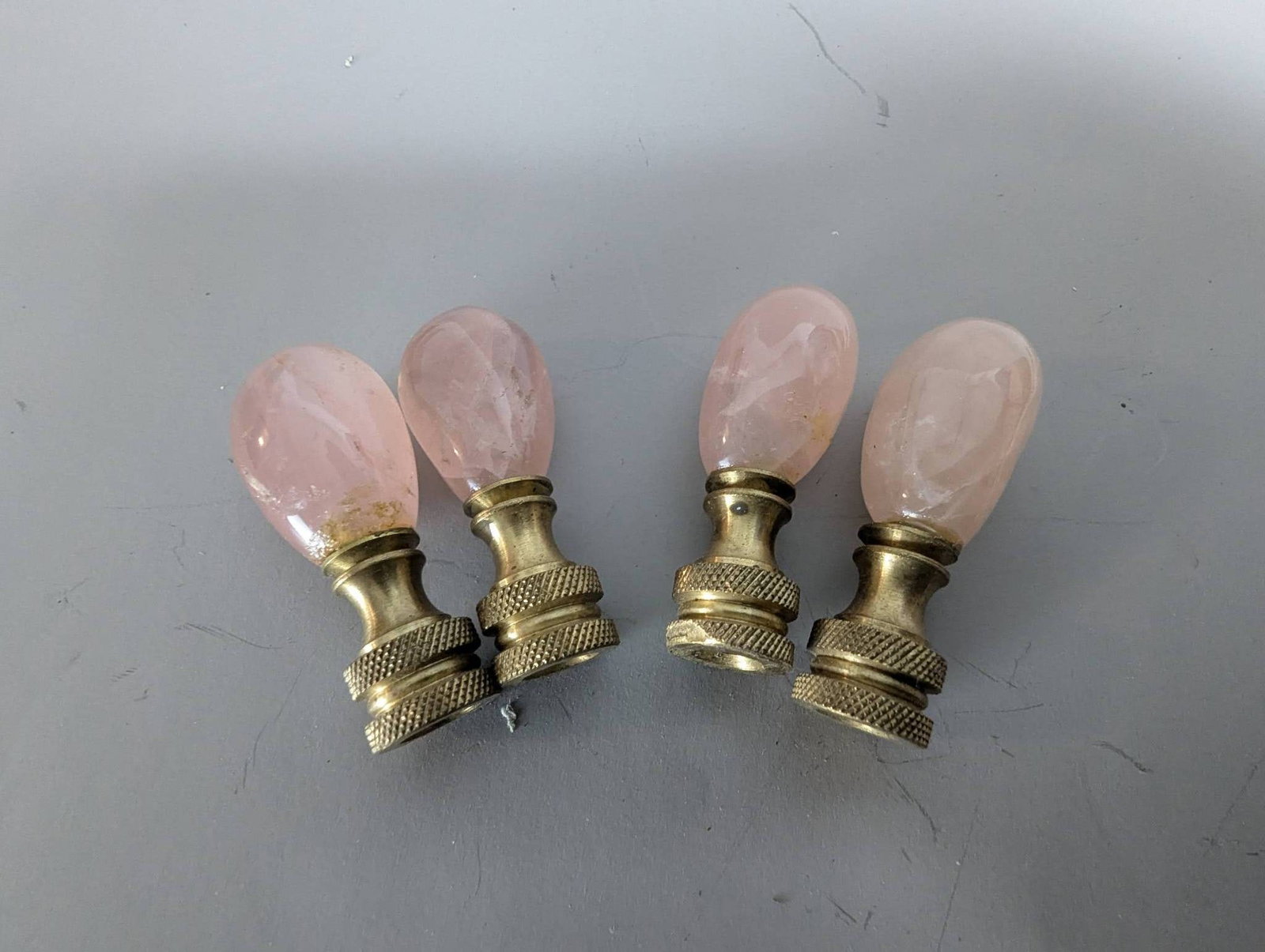 Four Rose Quartz Lamp Finials with Brass Bases: **Important** Please read below description on how to avoid high shipping costs. Four rose quartz lamp finials featuring brass bases with a textured grip design. Each finial measures 2 inches high by