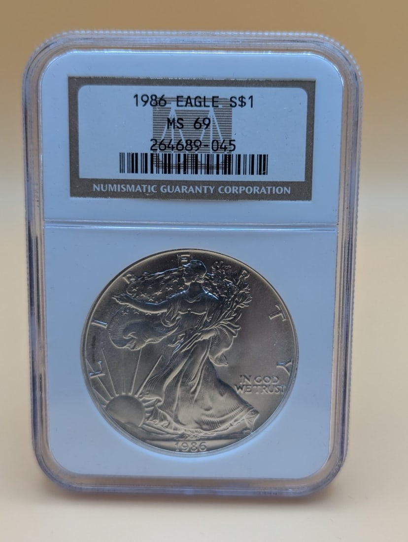 1986 American Silver Eagle S$1 Coin NGC MS 69 by Adolph A. Weinman: **Important** Please read below description on how to avoid high shipping costs. This 1986 American Silver Eagle is a must-have for any collector of iconic American coins. As the inaugural year of