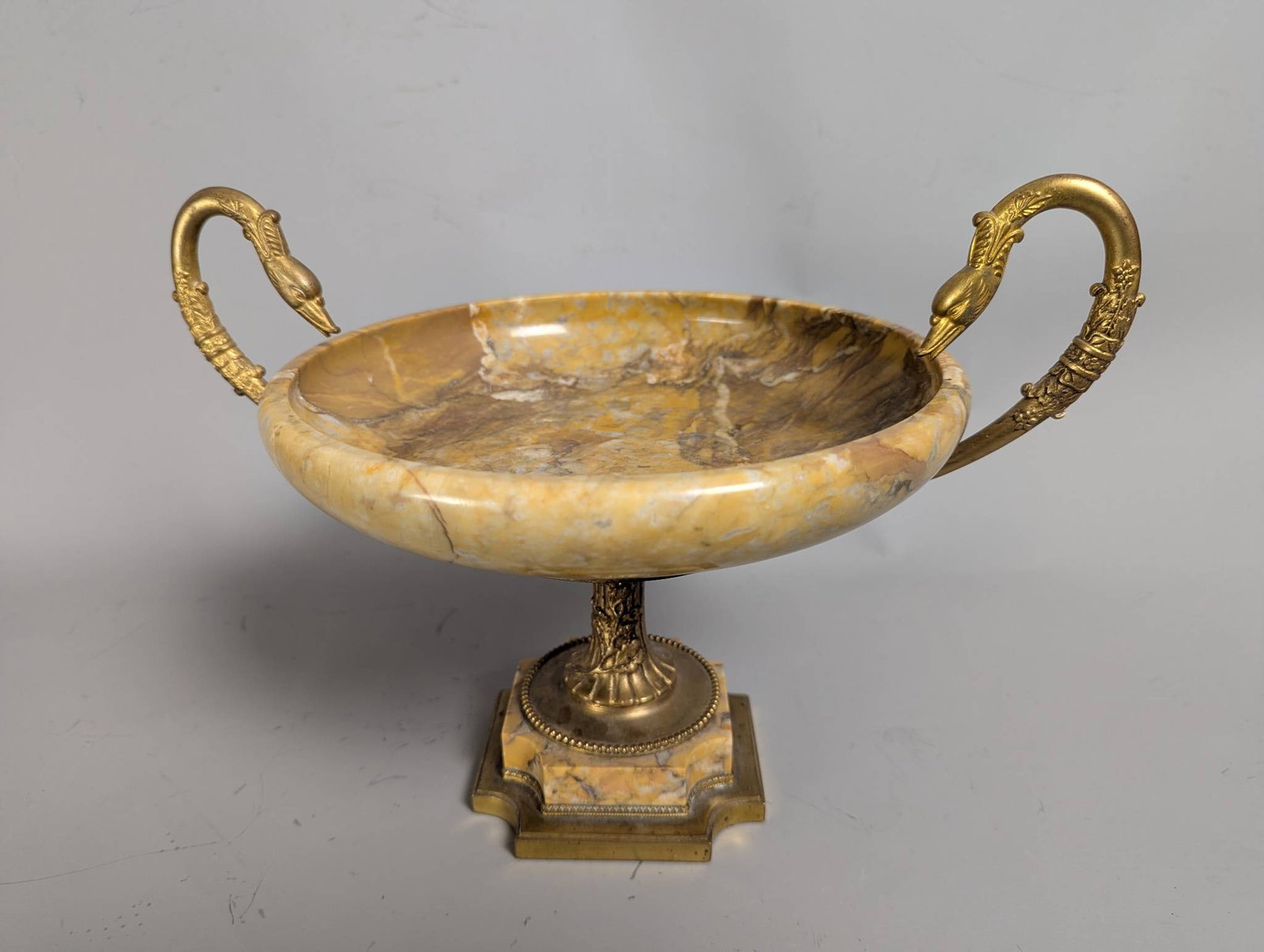 French Gilt Bronze and Marble Tazza with Swan-Form Handles: **Important** Please read below description on how to avoid high shipping costs. A French gilt bronze and marble tazza, likely originating from the 19th century. The tazza, designed in a Neoclassical 