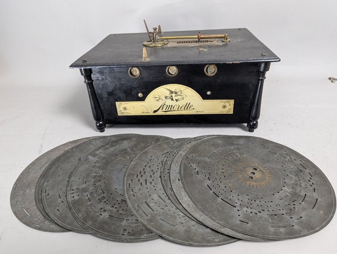 Antique Amorette Disc Music Box by Peters & Co with 10 Vintage Metal Discs: **Important** Please read below description on how to avoid high shipping costs. Experience the charm of yesteryears with this Antique Amorette Disc Music Box by Peters & Co. Measuring 17 x 12 x 8