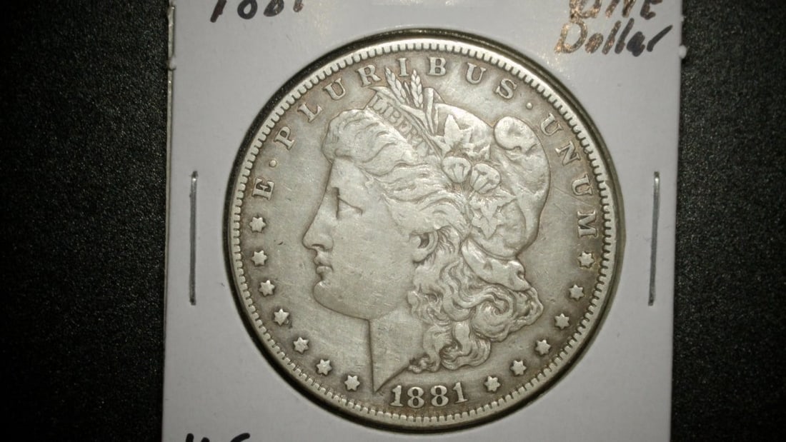1881 Morgan Silver Dollar VG by George T. Morgan - Circulated Coin: **Important** Please read below description on how to avoid high shipping costs. This exquisite 1881 Morgan Silver Dollar, designed by George T. Morgan, represents a significant piece of numismatic