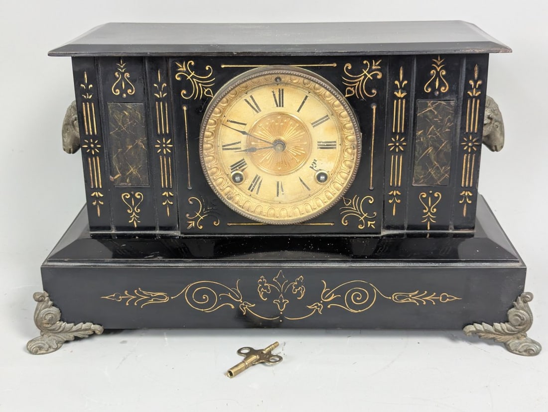 Antique Ansonia Triumph Black Metal Mantel Clock with Key and Pendulum: **Important** Please read below description on how to avoid high shipping costs. Presenting an Antique Ansonia 'Triumph' Black Metal Mantel Clock, measuring 10 high x 17 wide x 8 deep, complete with