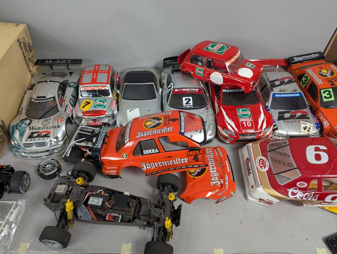 Lot of RC Cars 10 Body Shells Two Chassis Extra Parts Vintage Racing Collectibles: **Important** Please read below description on how to avoid high shipping costs. This lot contains a variety of RC car components as found, featuring 10 body shells and two chassis with extra parts. N
