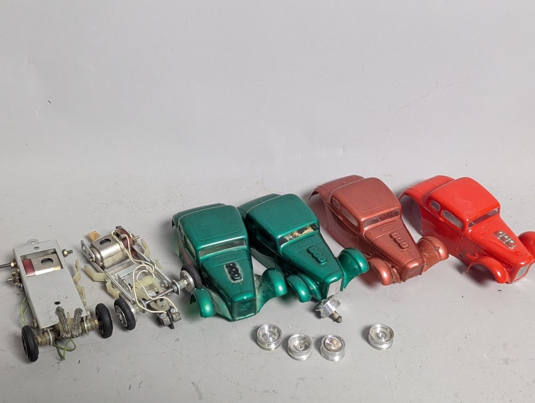 Vintage 1960s Slot Car Parts Lot - 1930s Ford Coupe Bodies, Chassis, Wheels Collection: **Important** Please read below description on how to avoid high shipping costs. Explore this exciting lot of vintage 1960s slot car parts, featuring four unique 1930s Ford Coupe bodies crafted from